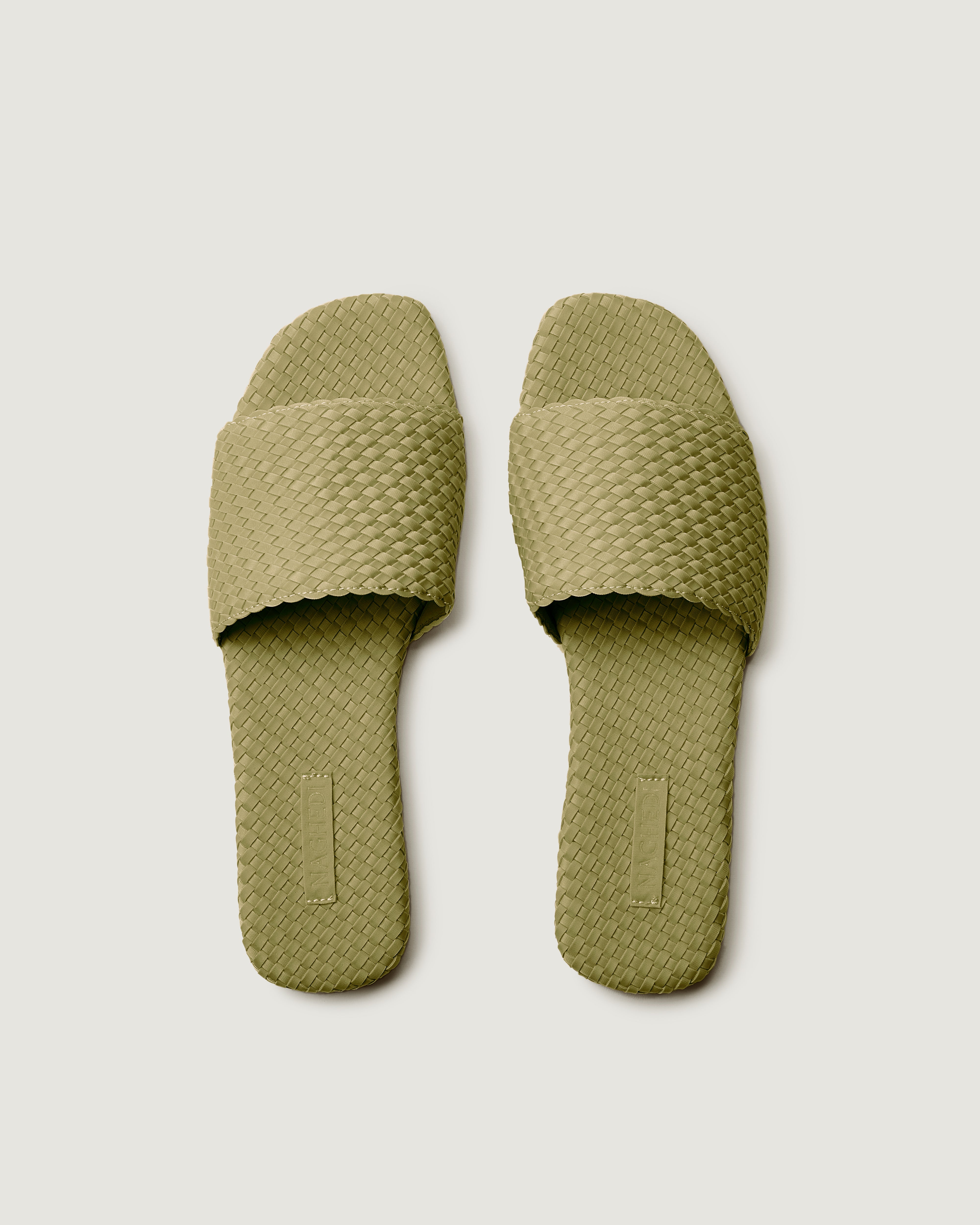 Top view of pair of The St. Barths Slide in Bottle Green showing the handwoven neoprene insole.