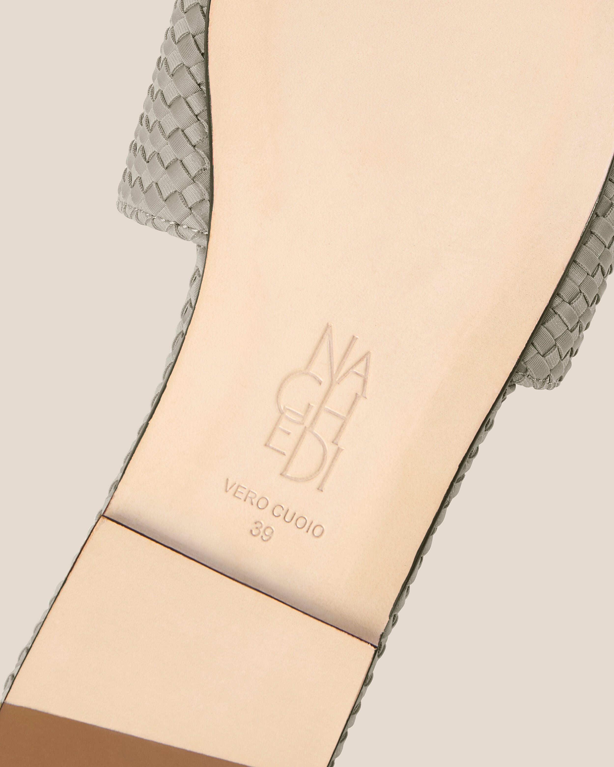 Shoe sole showing natural buffed leather sole, stamped NAGHEDI logo and size detail for The St. Barths Slide in Celadon.
