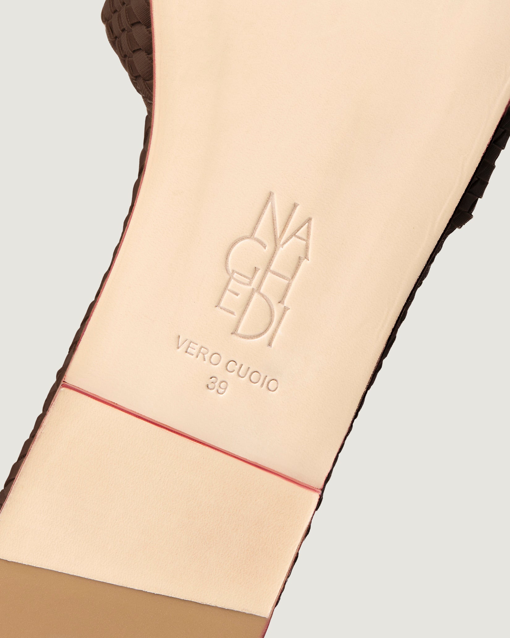 Shoe sole showing natural buffed leather sole, stamped NAGHEDI logo and size detail for St. Barths Slide Sandals in Chocolate.