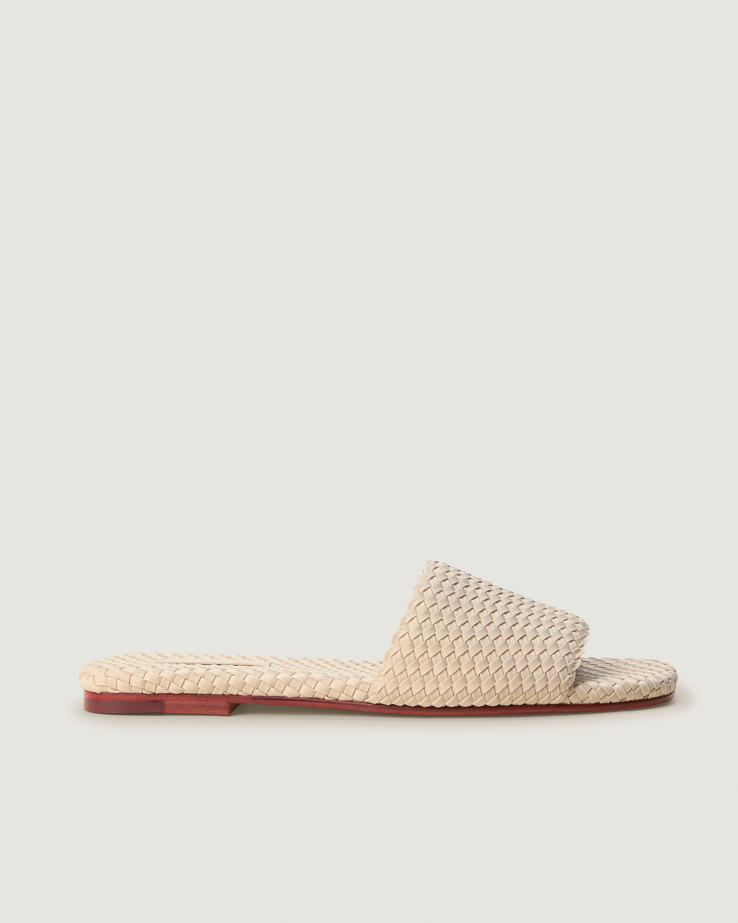 Side view of The St. Barths Slide in Ecru, a cream tone, featuring an open toe and square silhouette.