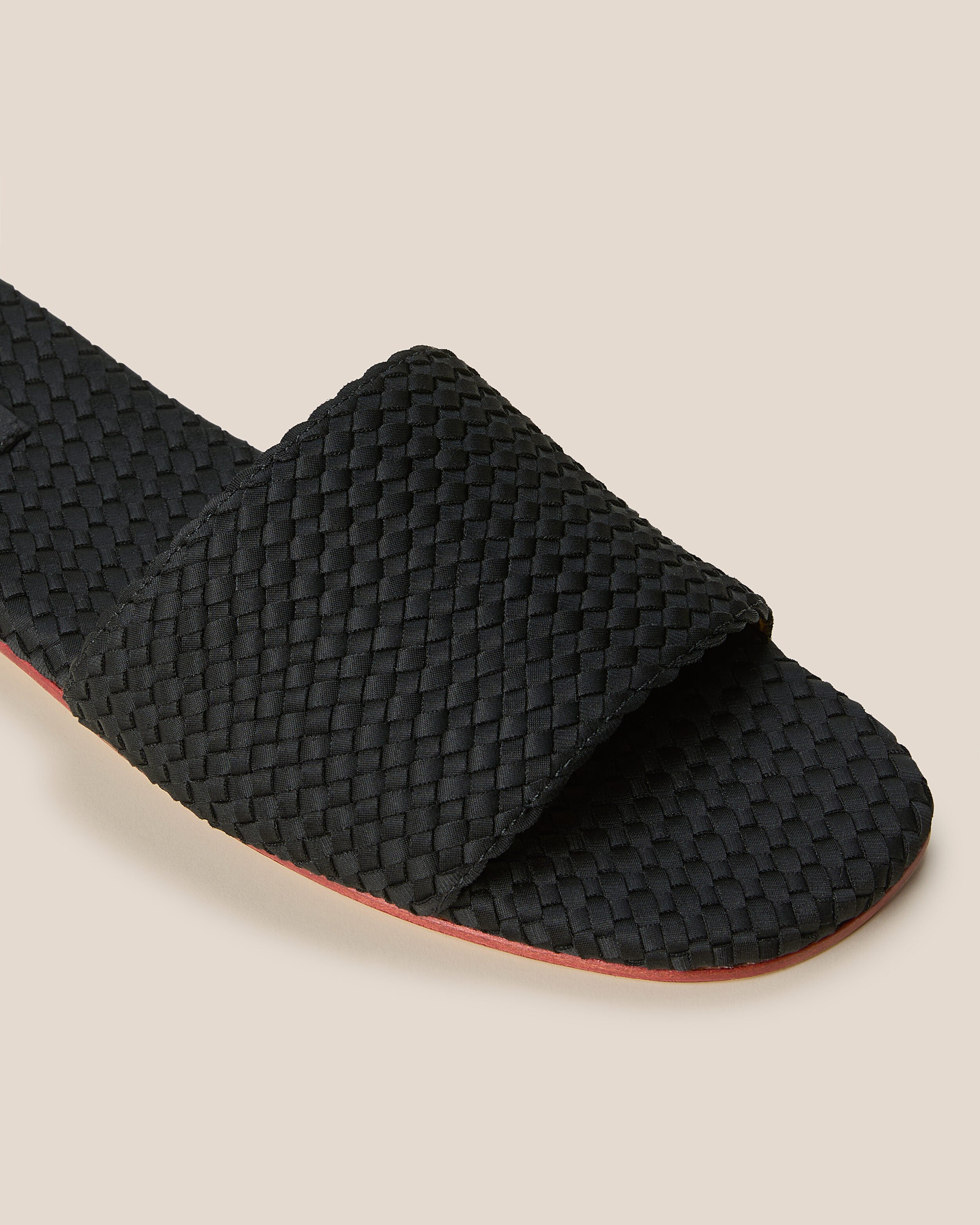 Close-up of The St. Barths Slide in Onyx showing its open toe and square silhouette.