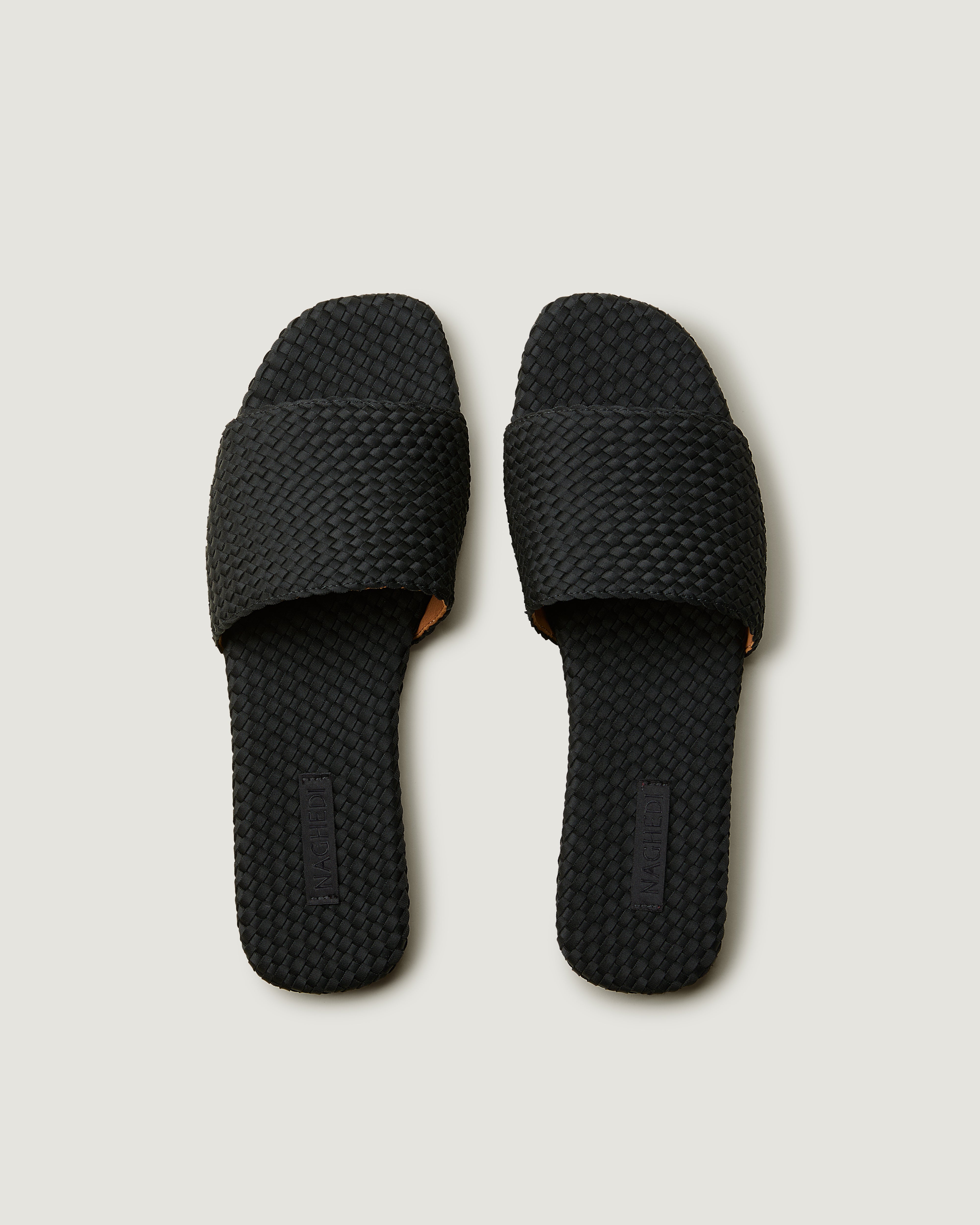 Top view of pair of The St. Barths Slide in Onyx showing the handwoven neoprene insole.