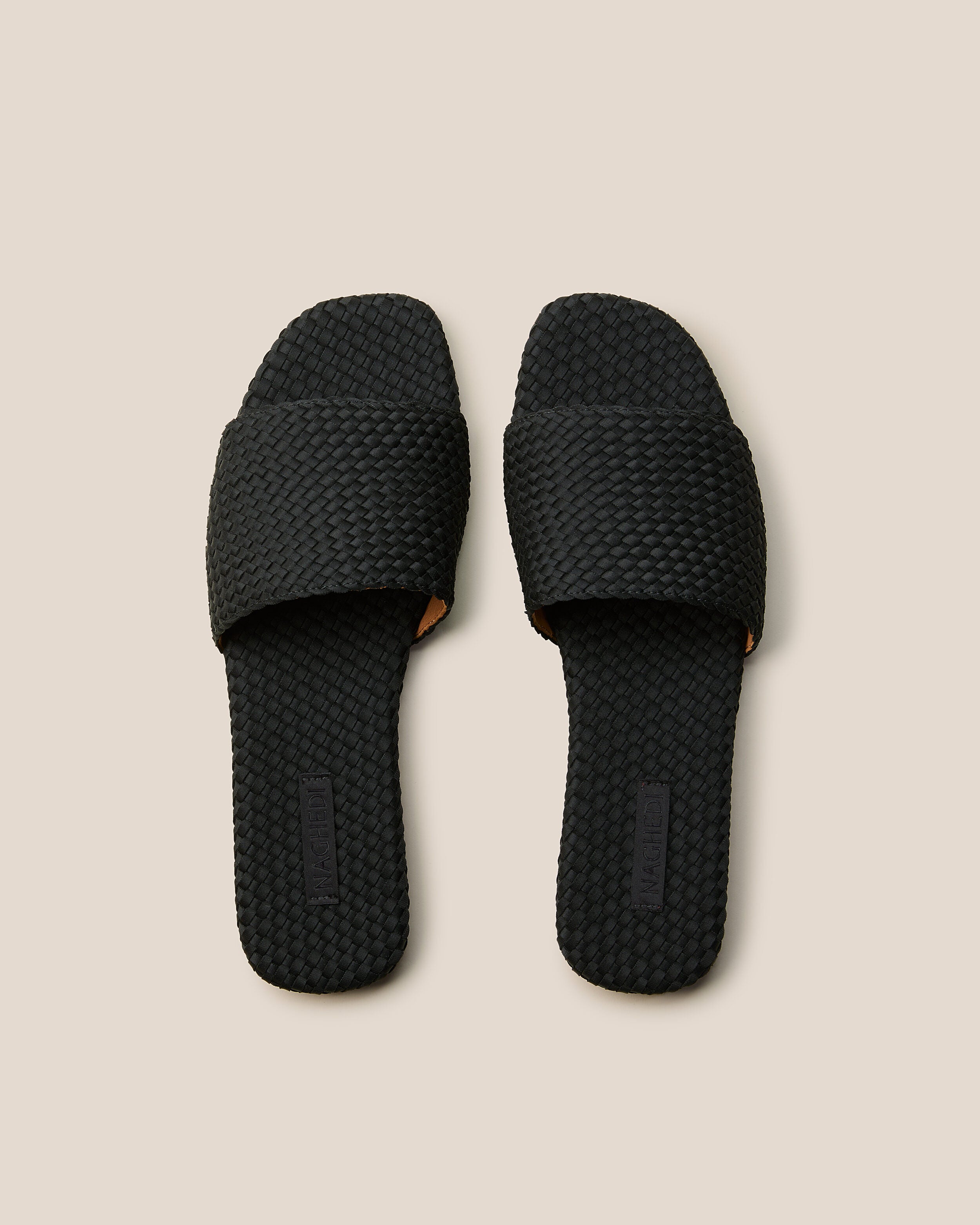 Top view of pair of The St. Barths Slide in Onyx showing the handwoven neoprene insole.