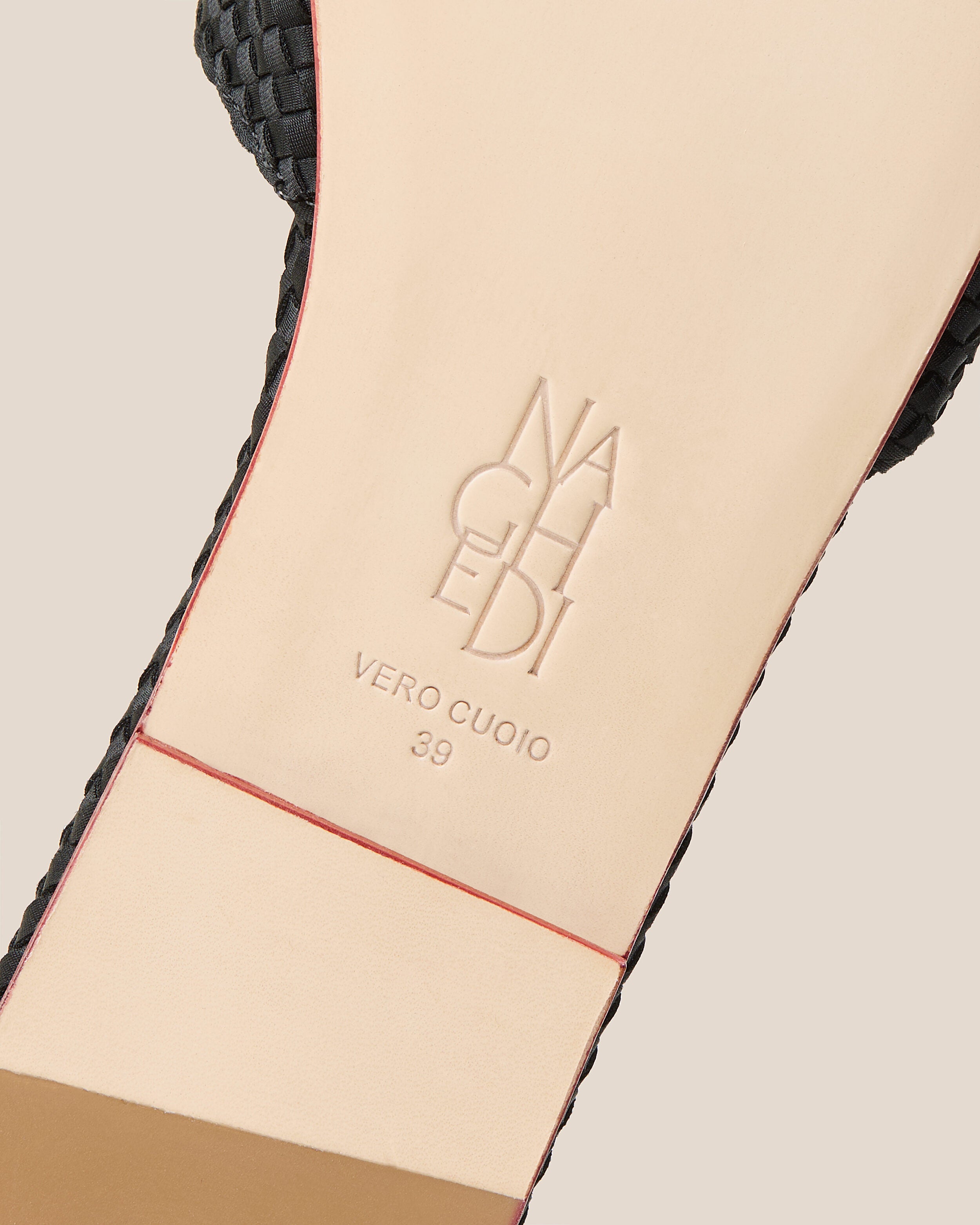 Shoe sole showing natural buffed leather sole, stamped NAGHEDI logo and size detail for The St. Barths Slide in Onyx.