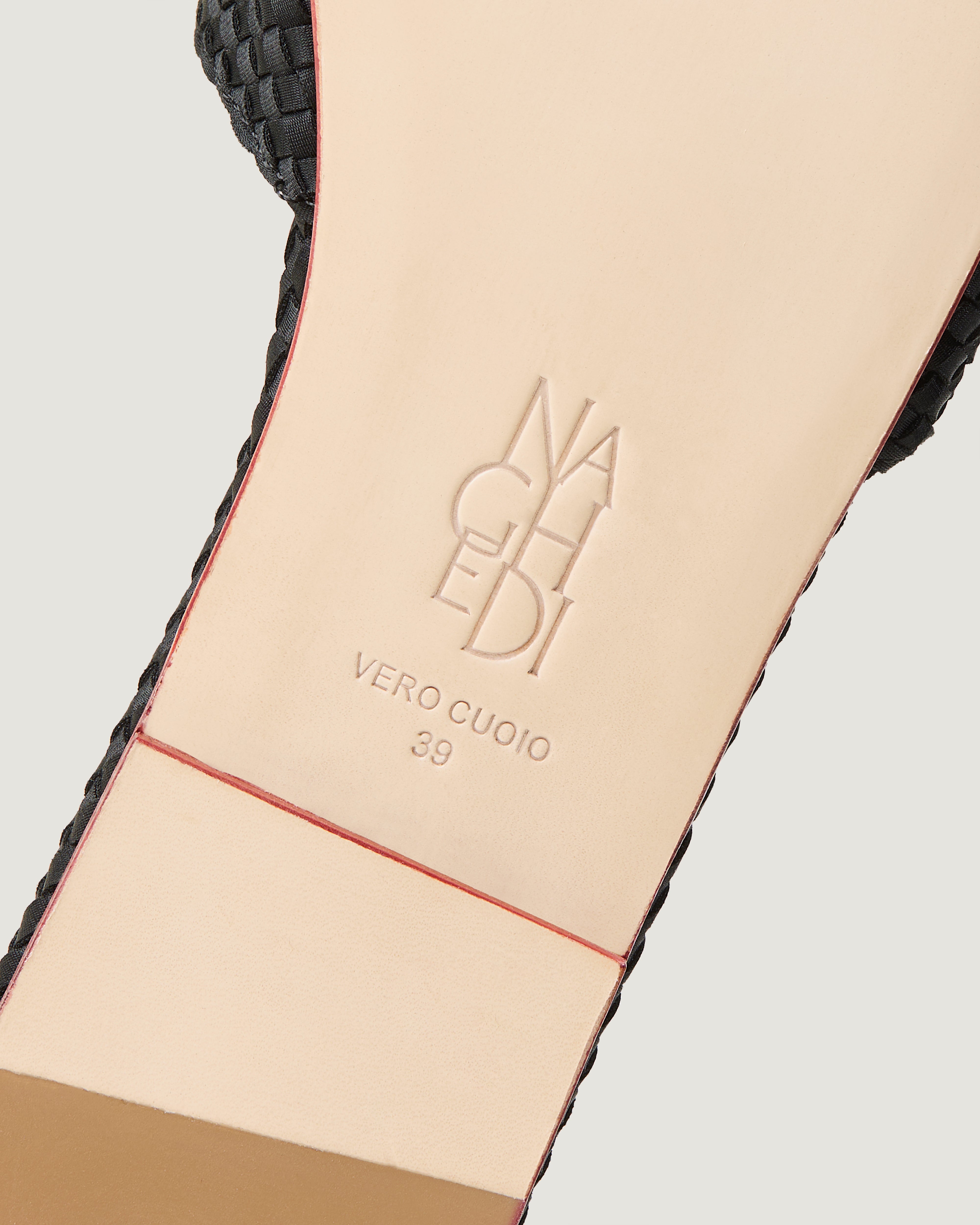 Shoe sole showing natural buffed leather sole, stamped NAGHEDI logo and size detail for The St. Barths Slide in Onyx.