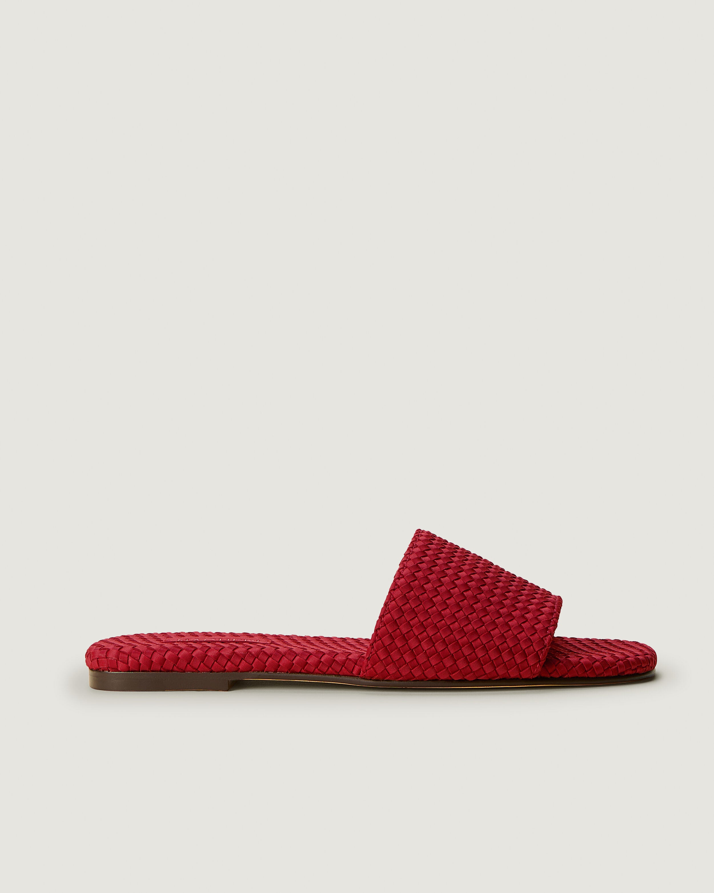 Side view of The St. Barths Slide in Rosso, a rich red tone, featuring an open toe and square silhouette.