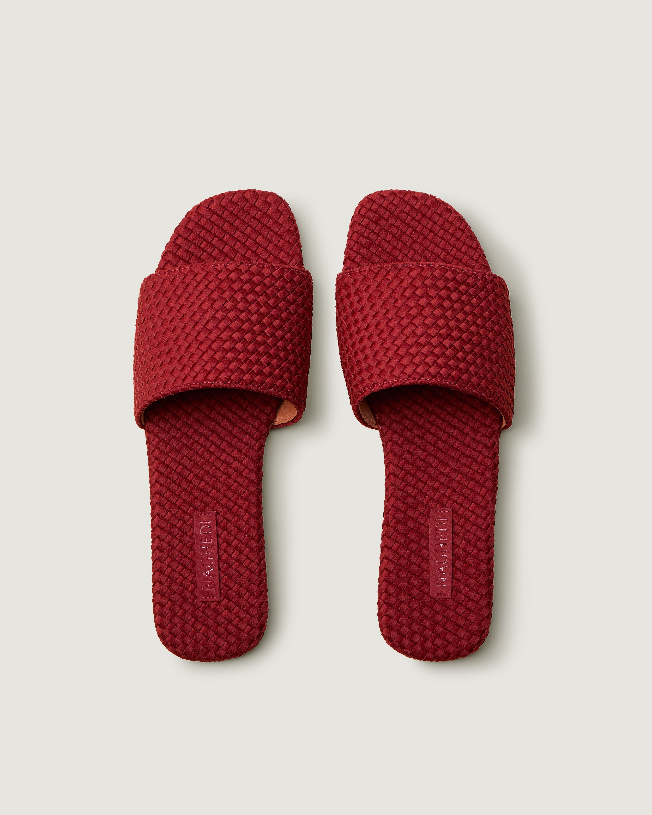 Top view of pair of The St. Barths Slide in Rosso showing the handwoven neoprene insole.