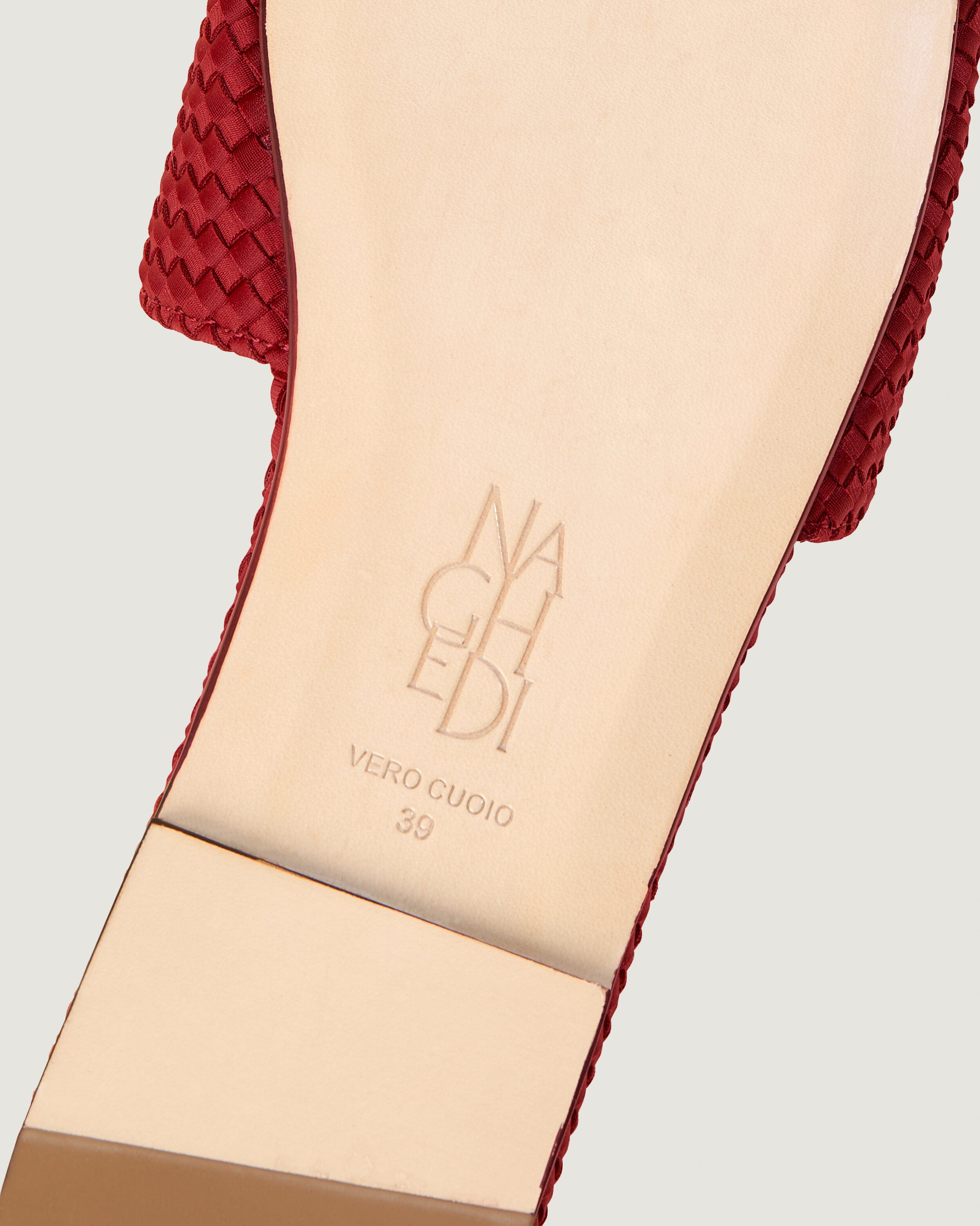 Shoe sole showing natural buffed leather sole, stamped NAGHEDI logo and size detail for The St. Barths Slide in Rosso.