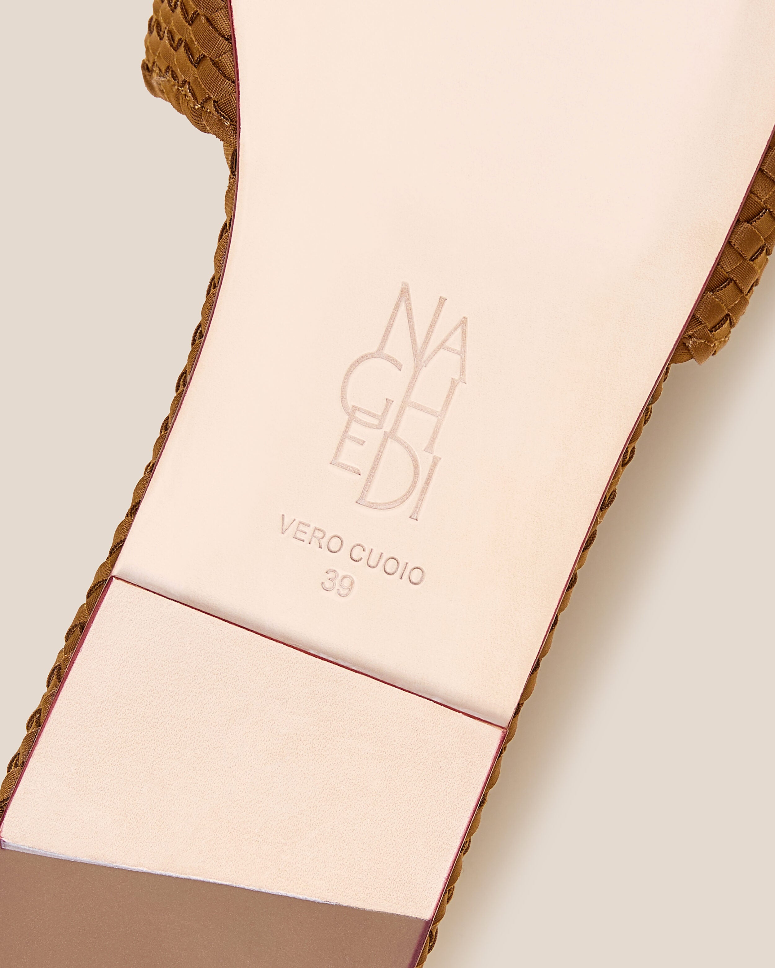 Shoe sole showing natural buffed leather sole, stamped NAGHEDI logo and size detail for The St. Barths Slide in Teak.