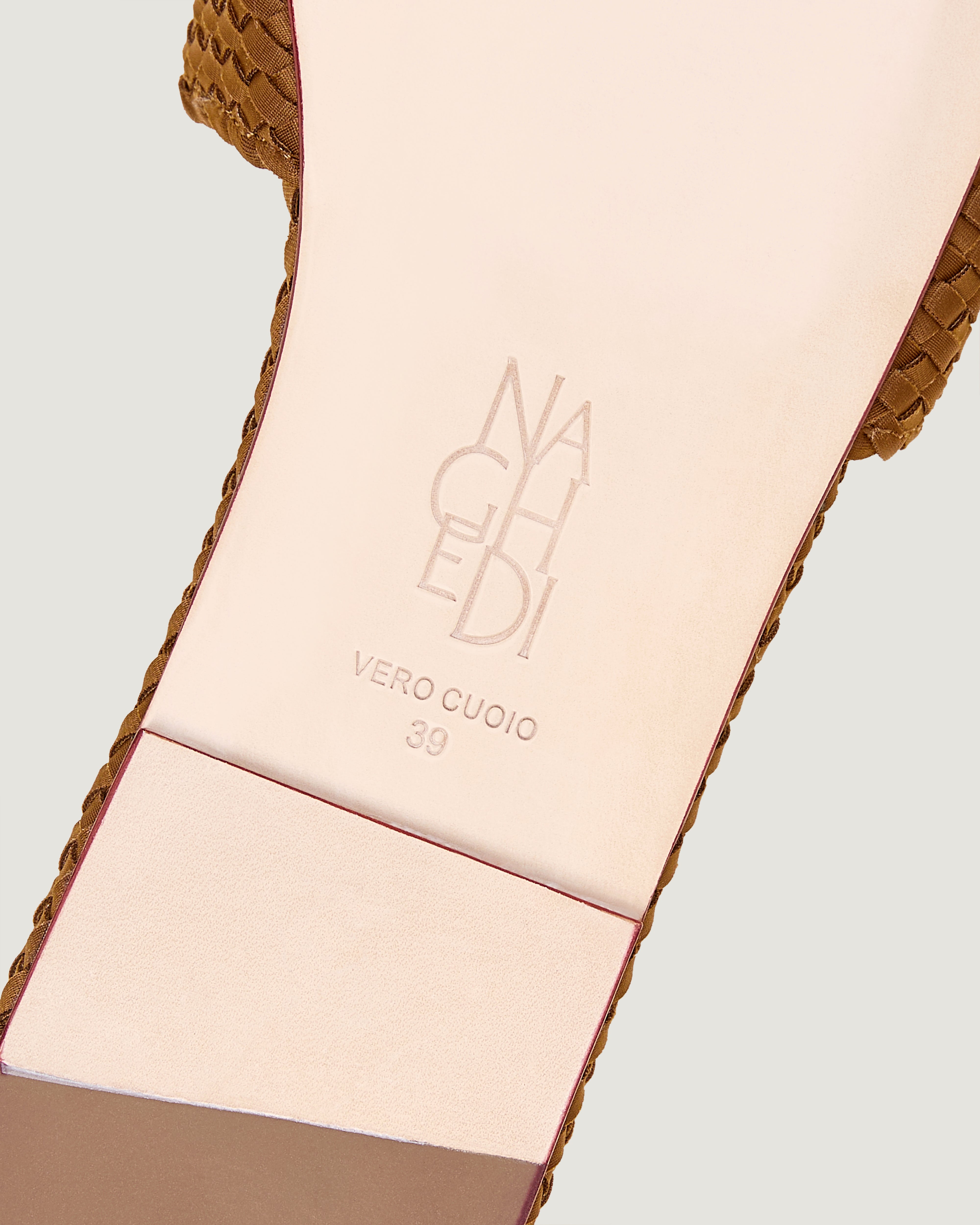 Shoe sole showing natural buffed leather sole, stamped NAGHEDI logo and size detail for The St. Barths Slide in Teak.