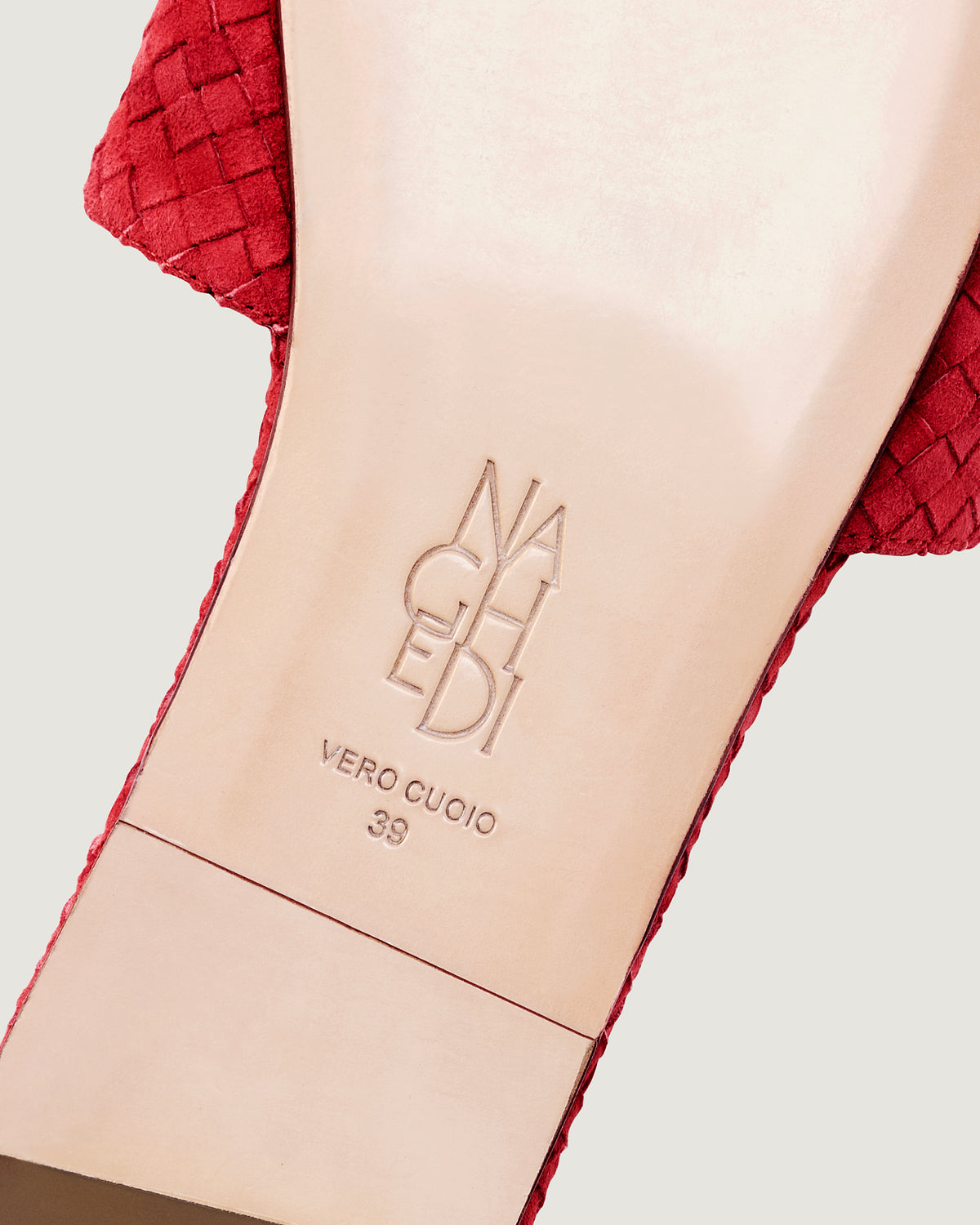 Shoe sole showing natural buffed leather sole, stamped NAGHEDI logo and size detail for The St. Barths Slide in Cerise.