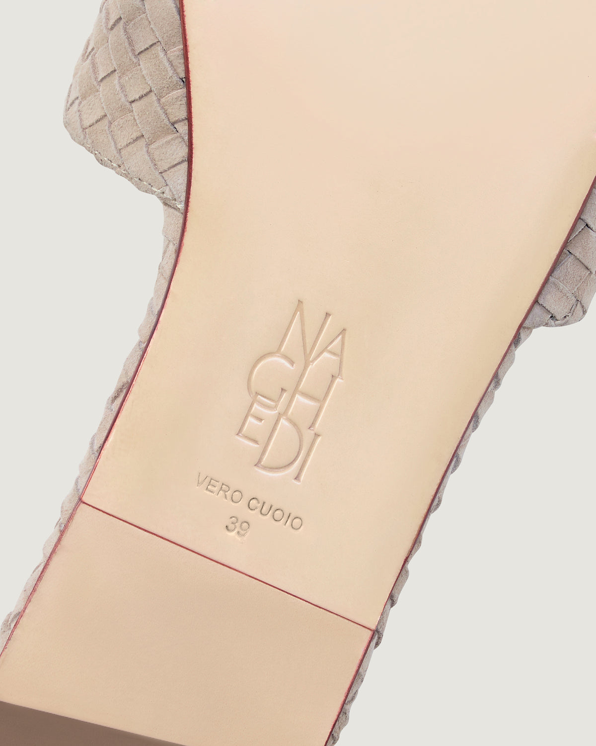 Shoe sole showing natural buffed leather sole, stamped NAGHEDI logo and size detail for The St. Barths Slide in Linen.