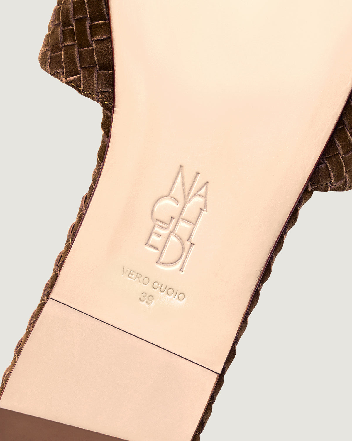 Shoe sole showing natural buffed leather sole, stamped NAGHEDI logo and size detail for The St. Barths Slide in Teak.