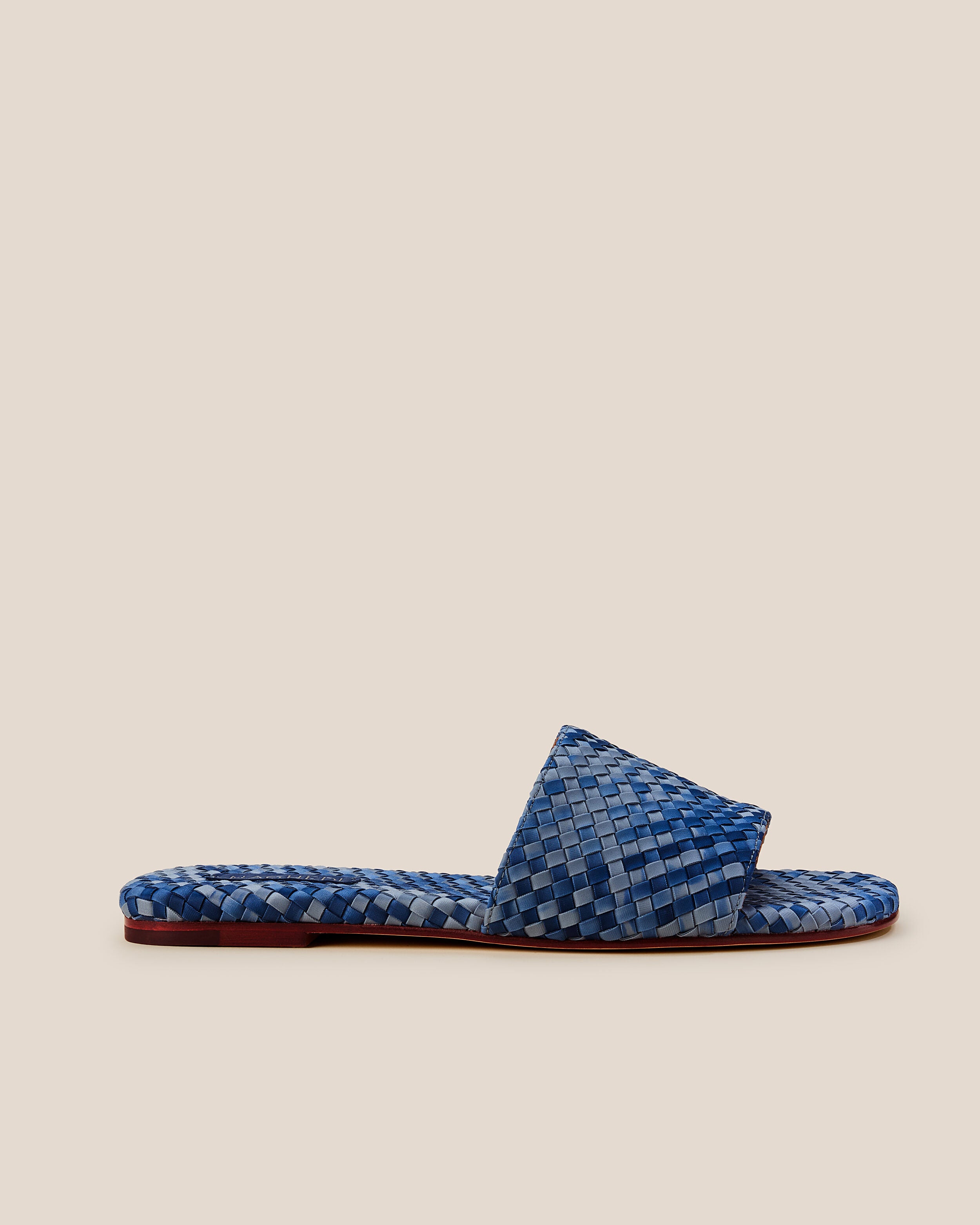 Side view of The St. Barths Slide in Paros, a denim blue and navy tone, featuring an open toe and square silhouette.