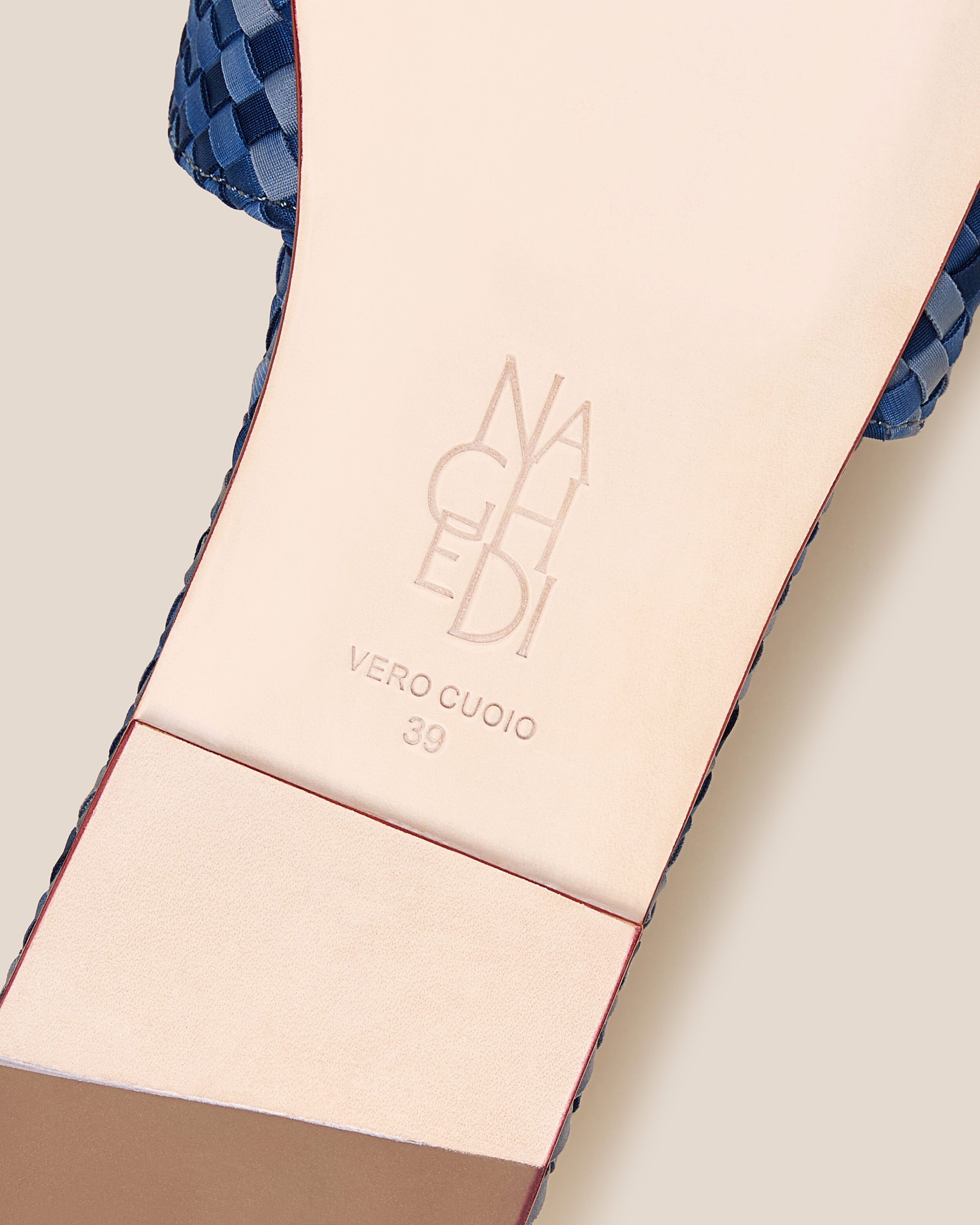 Shoe sole showing natural buffed leather sole, stamped NAGHEDI logo and size detail for The St. Barths Slide in Paros.