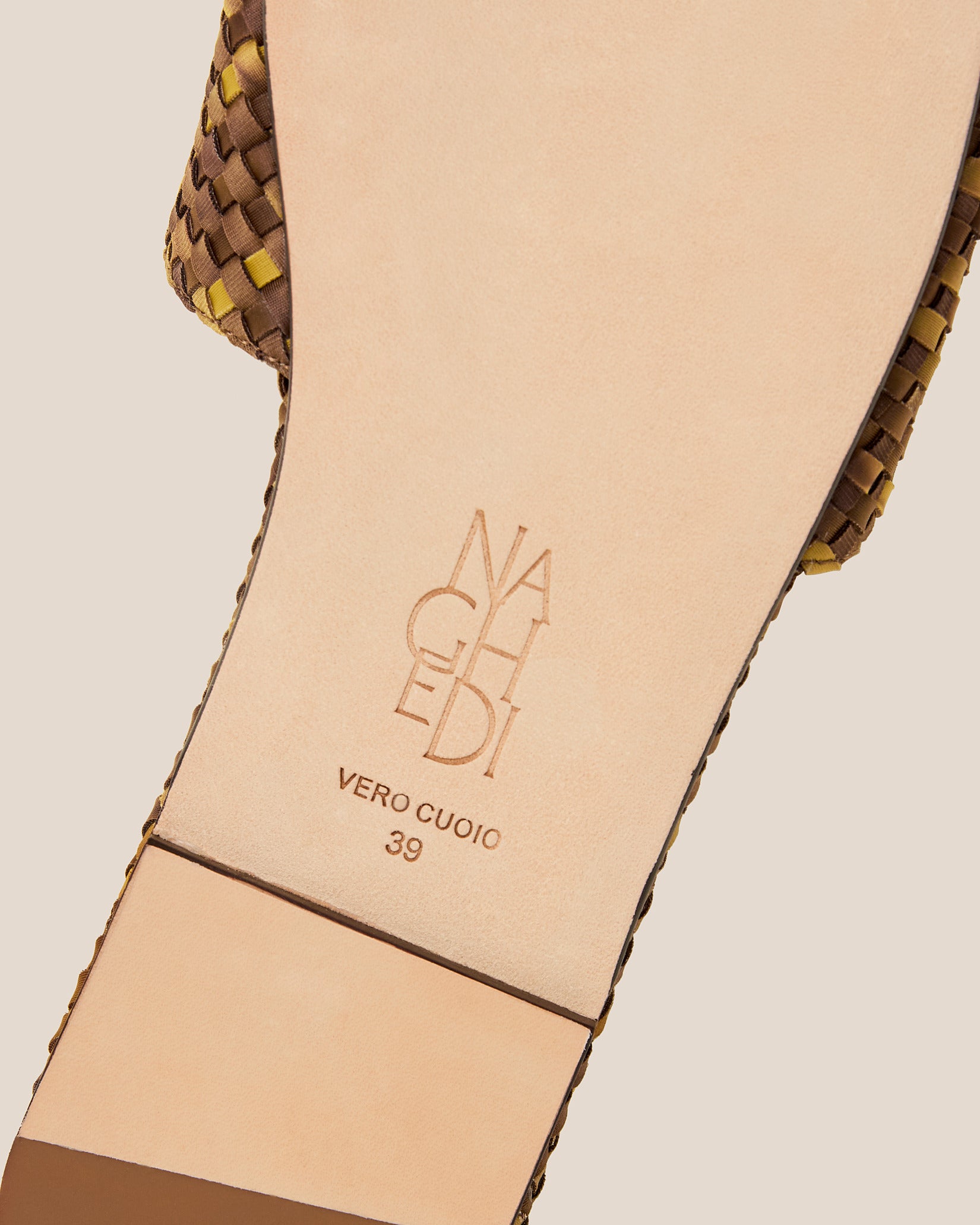 Shoe sole showing natural buffed leather sole, stamped NAGHEDI logo and size detail for St. Barths Watercolor Slide Sandals in Tortoiseshell.
