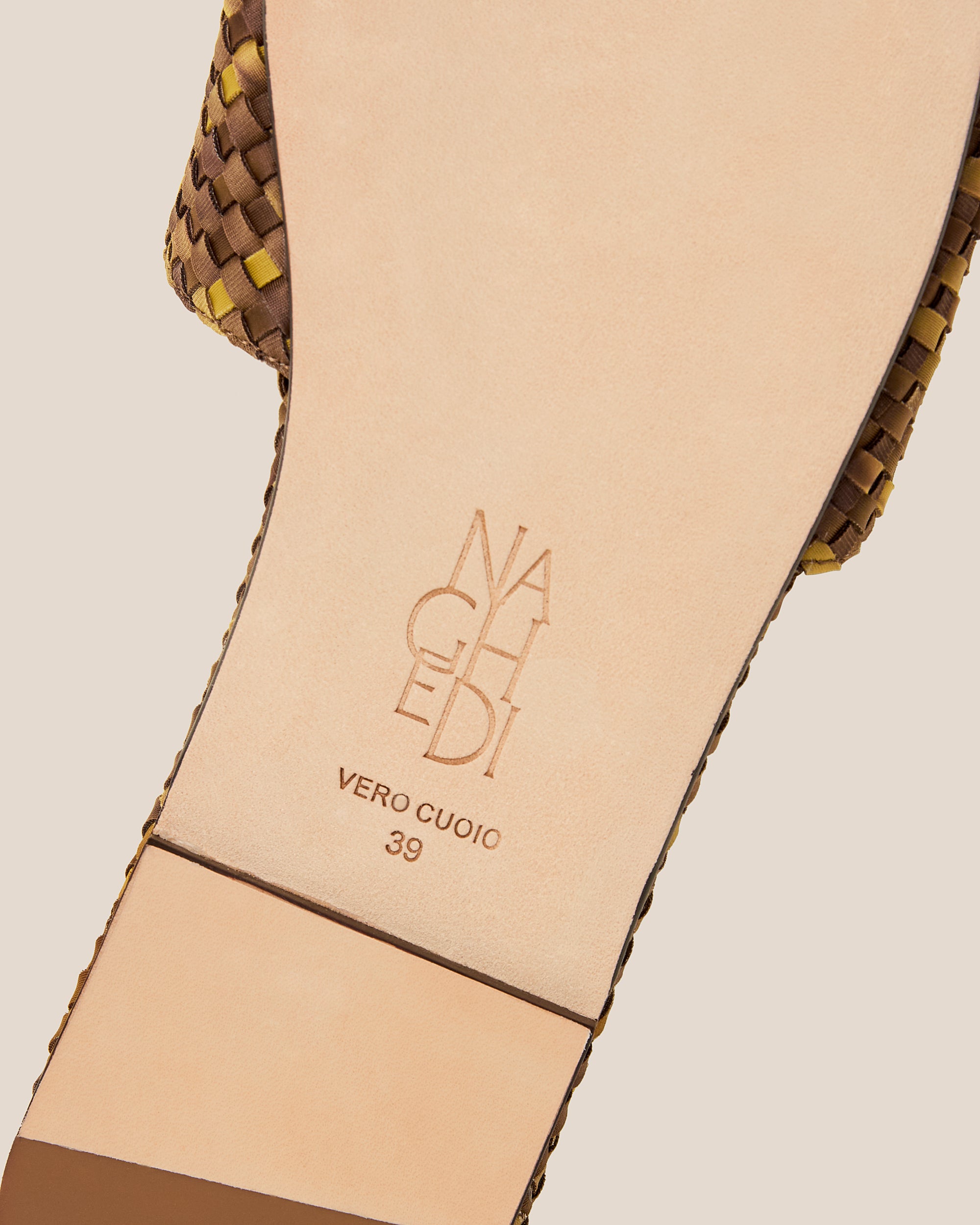 Shoe sole showing natural buffed leather sole, stamped NAGHEDI logo and size detail for St. Barths Watercolor Slide Sandals in Tortoiseshell.