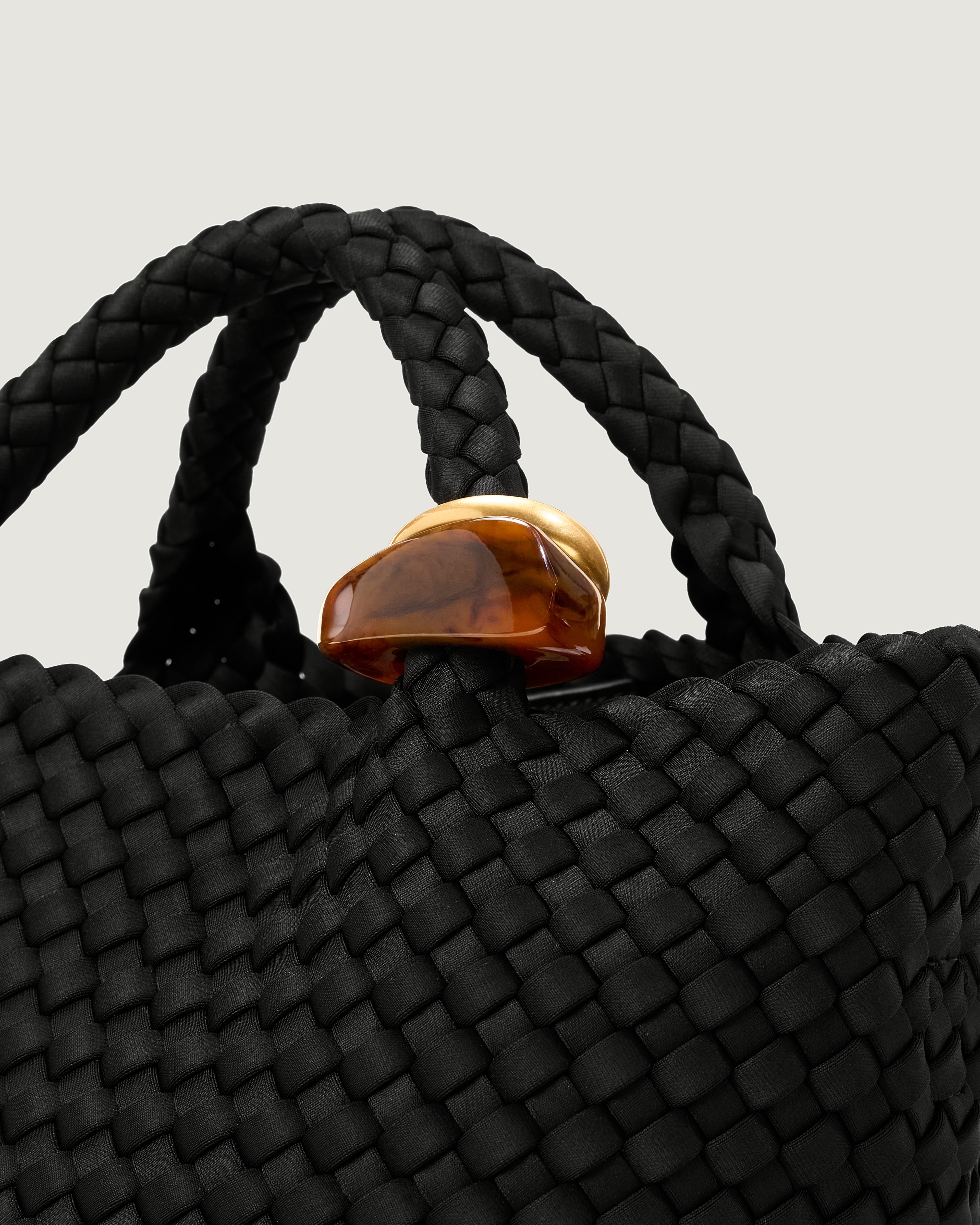 Close up of the St Barths Tote in Onyx highlighting the 2 beads on the handle.