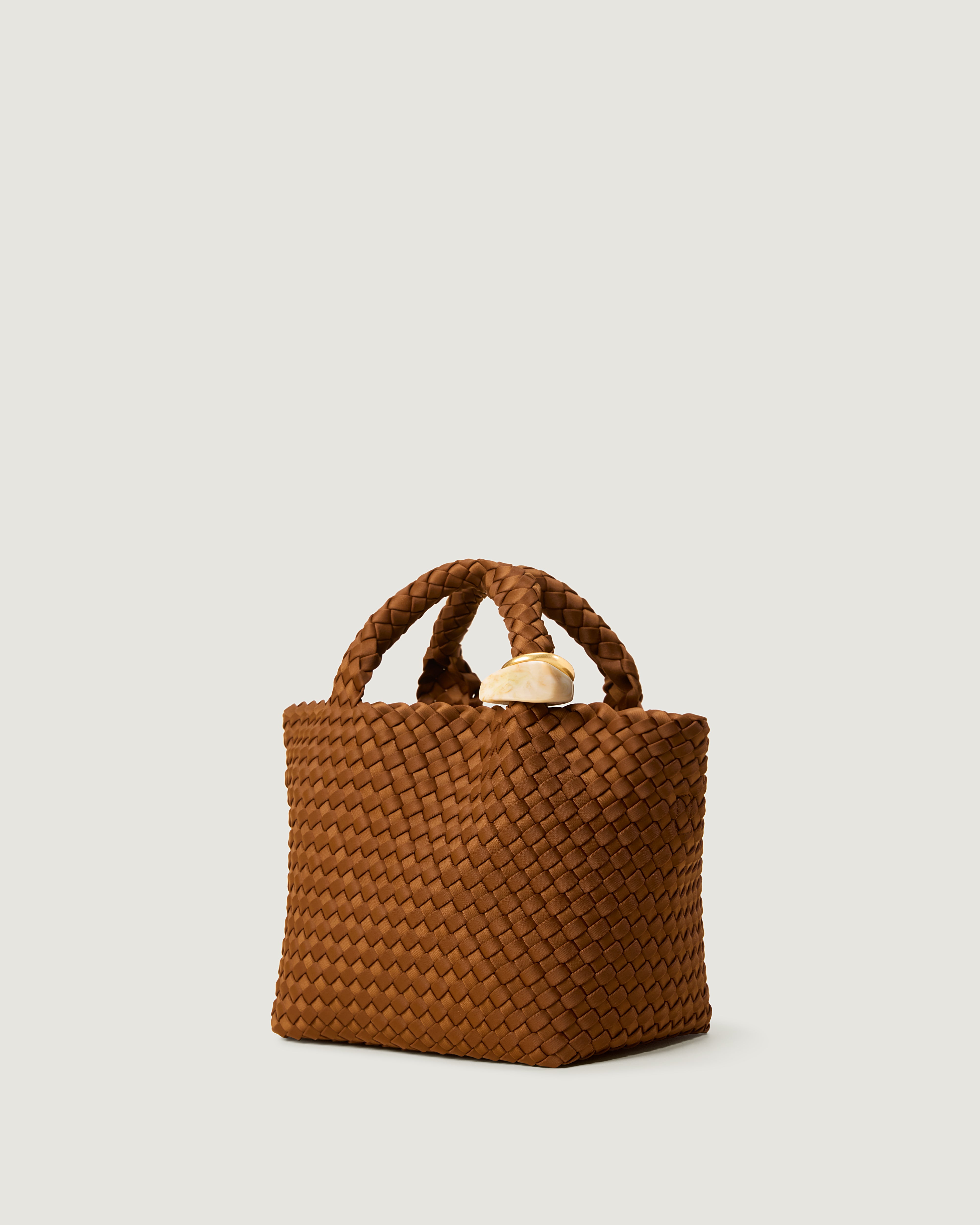 St. Barths Tote in Teak shown from a side angle, highlighting its handwoven neoprene construction and open top.