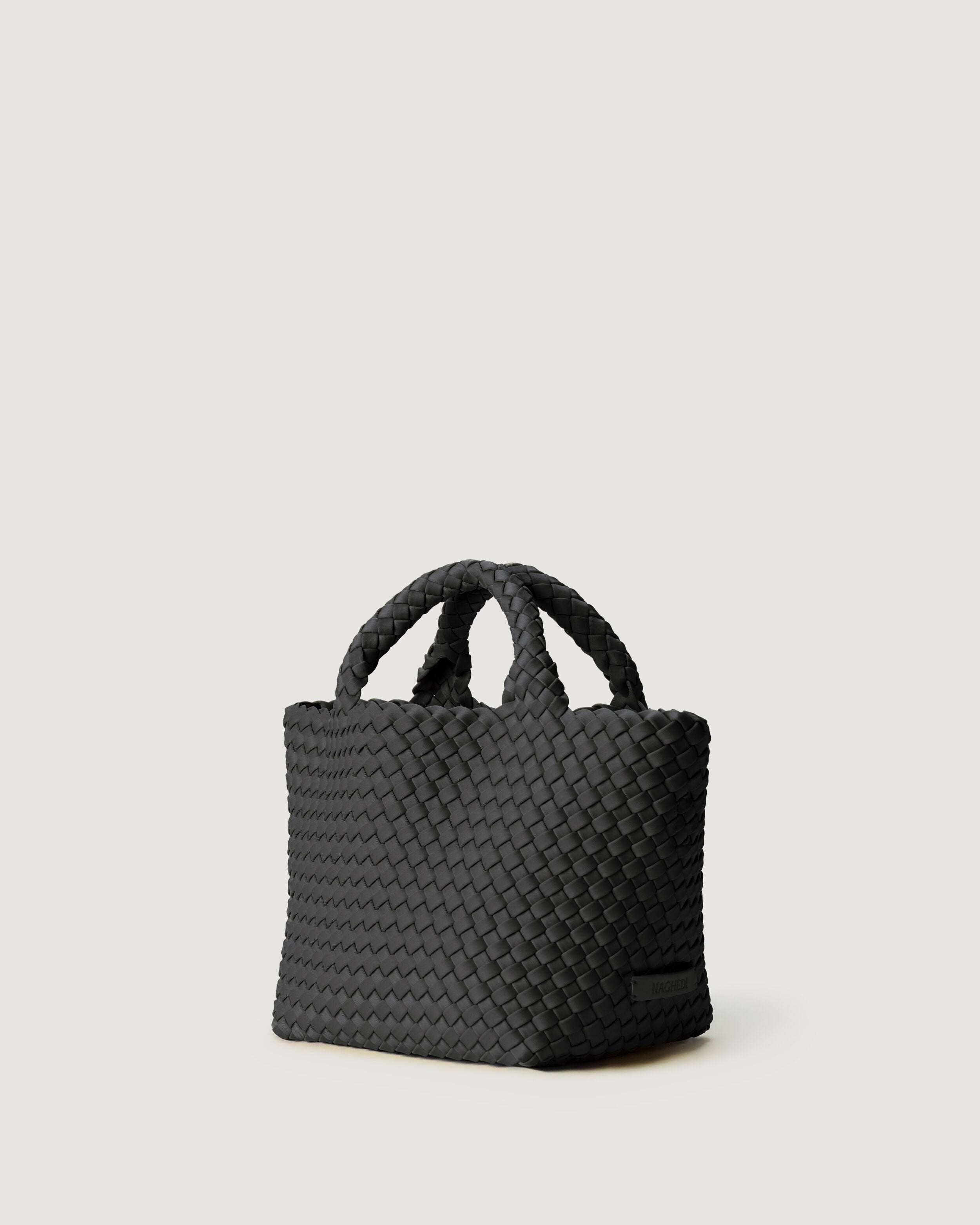St. Barths Tote in Ash shown from a side angle, highlighting its handwoven neoprene construction and open top.
