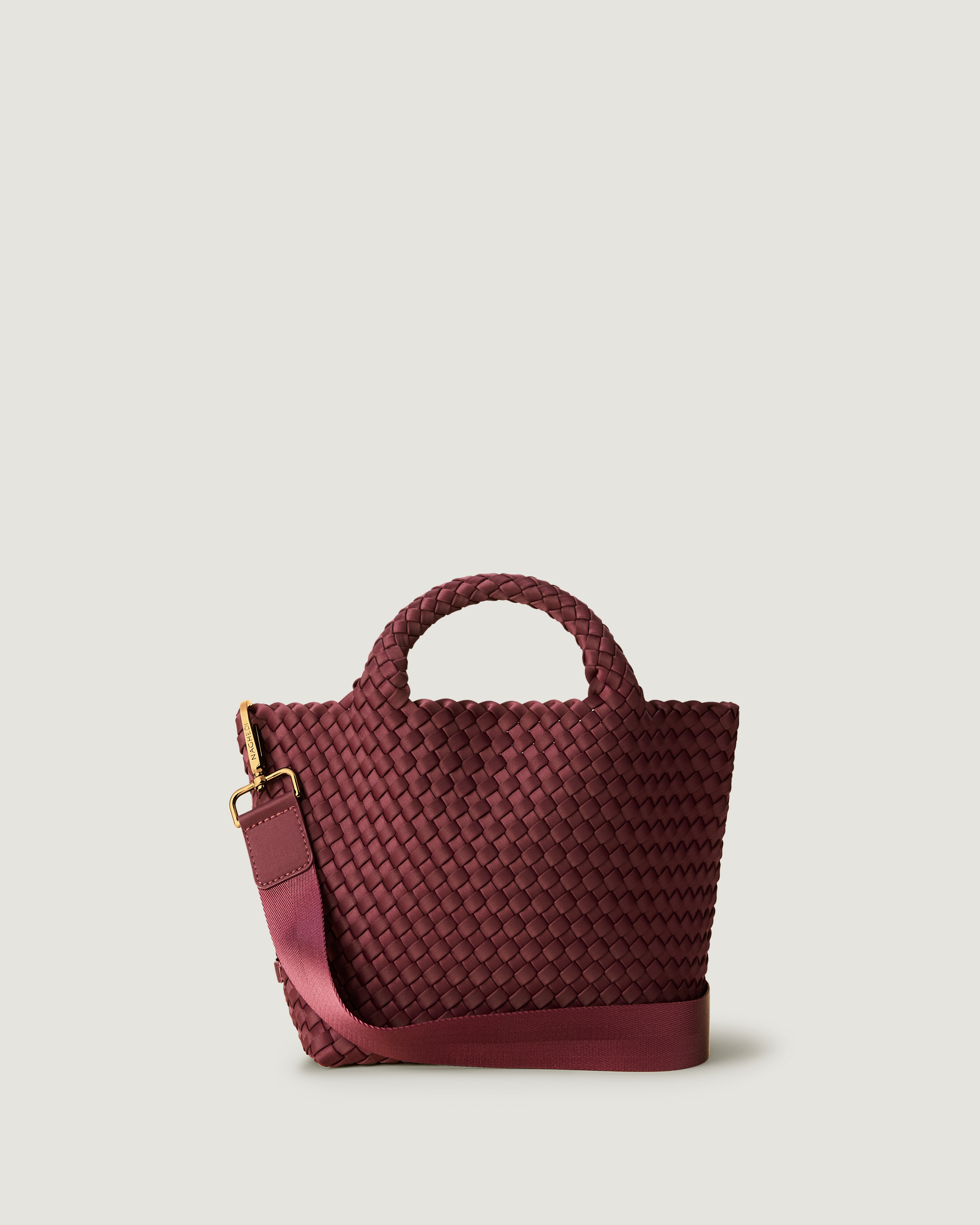 St. Barths Tote in Bordeaux, handwoven in burgundy neoprene. Featuring an open top, adjustable shoulder strap, and woven top handles.