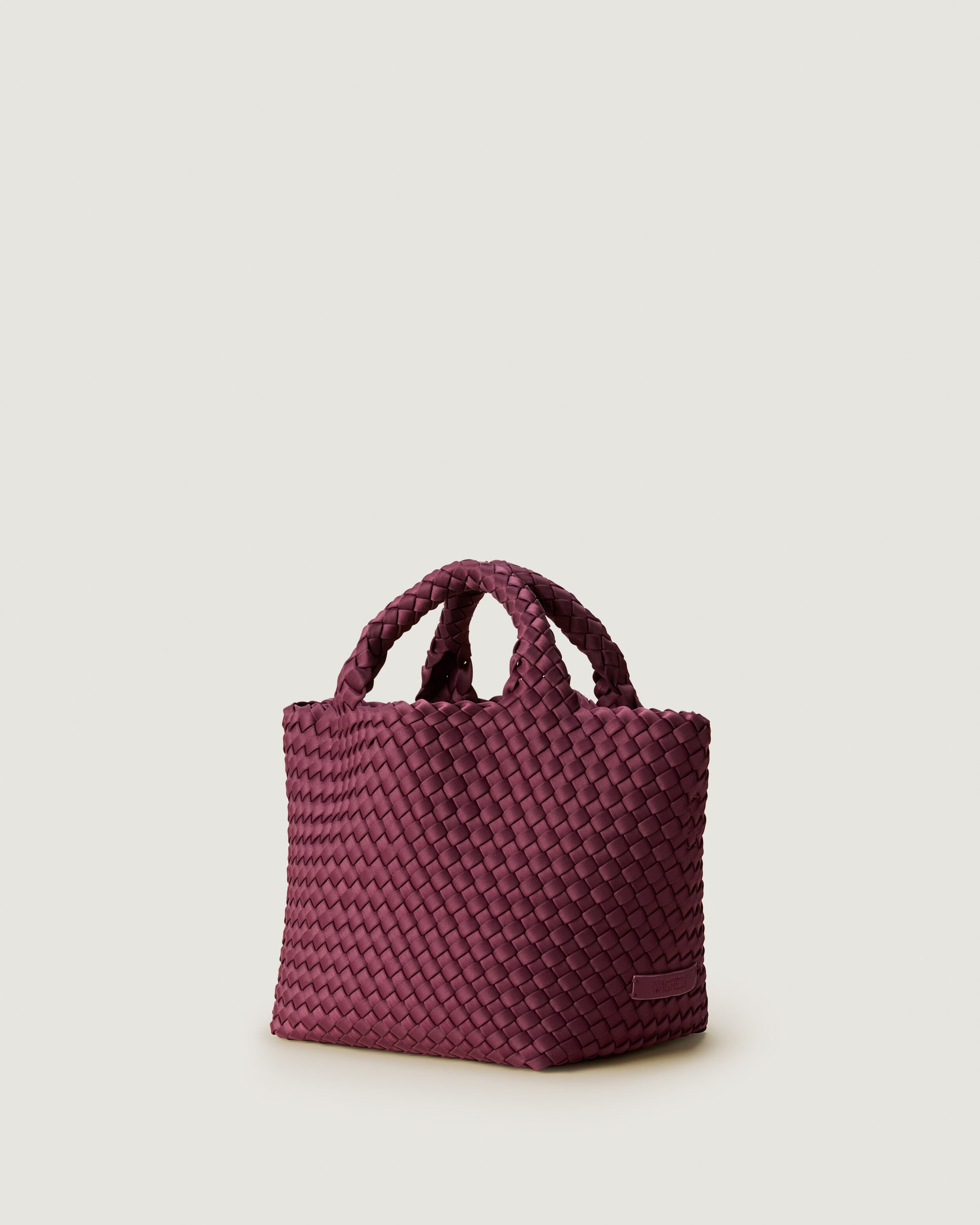 St. Barths Tote in Bordeaux shown from a side angle, highlighting its handwoven neoprene construction and open top.