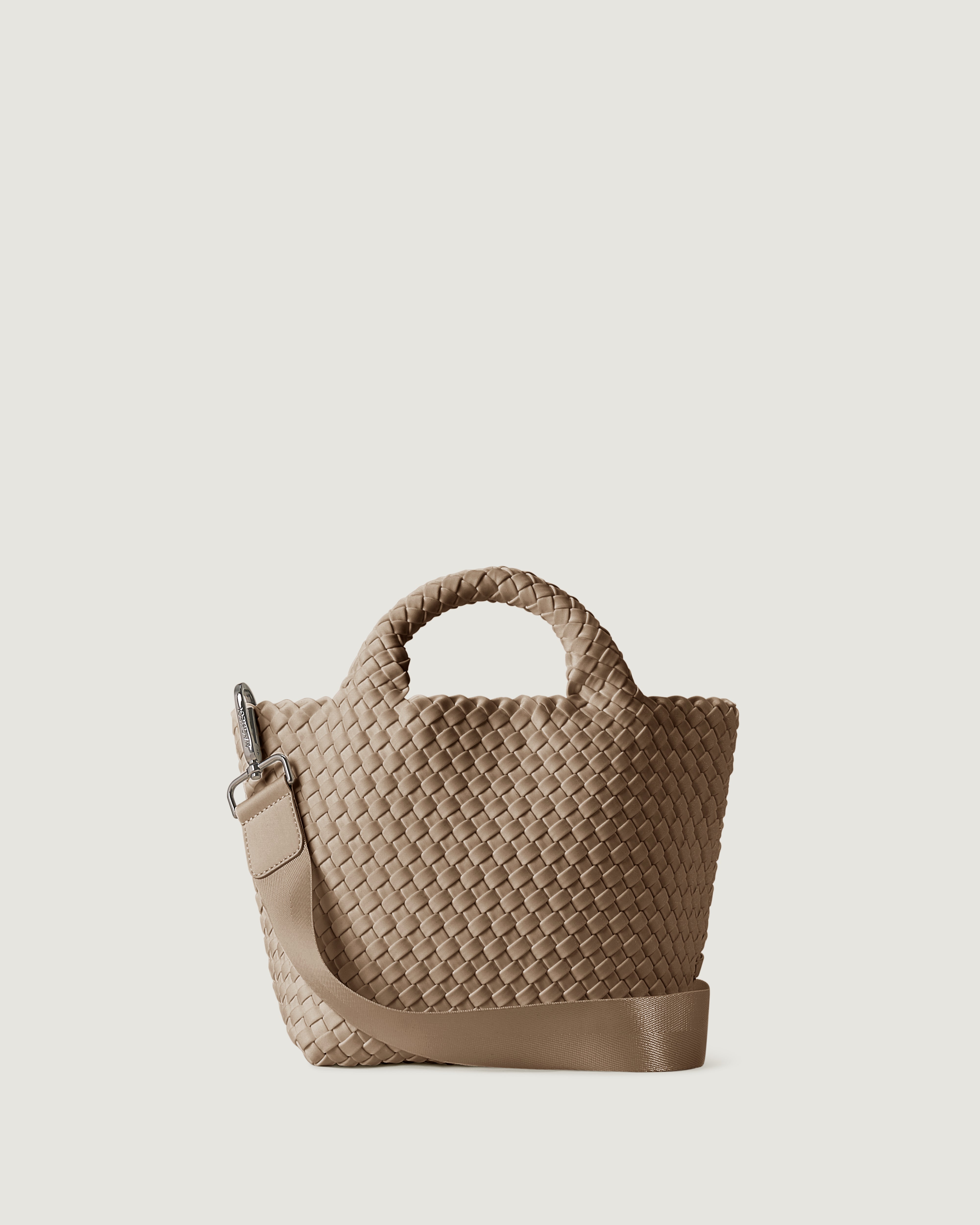 St. Barths Tote in Cashmere, a taupe tone, in handwoven neoprene, featuring an open top, woven top handles, and detachable, adjustable nylon crossbody strap.