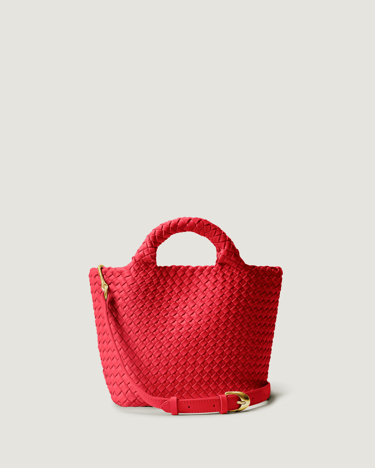 St. Barths Tote in Ink Cerise, a bright cherry red tone, in handwoven neoprene, featuring an magnetic closure, woven top handles, and detachable, adjustable leather crossbody strap.