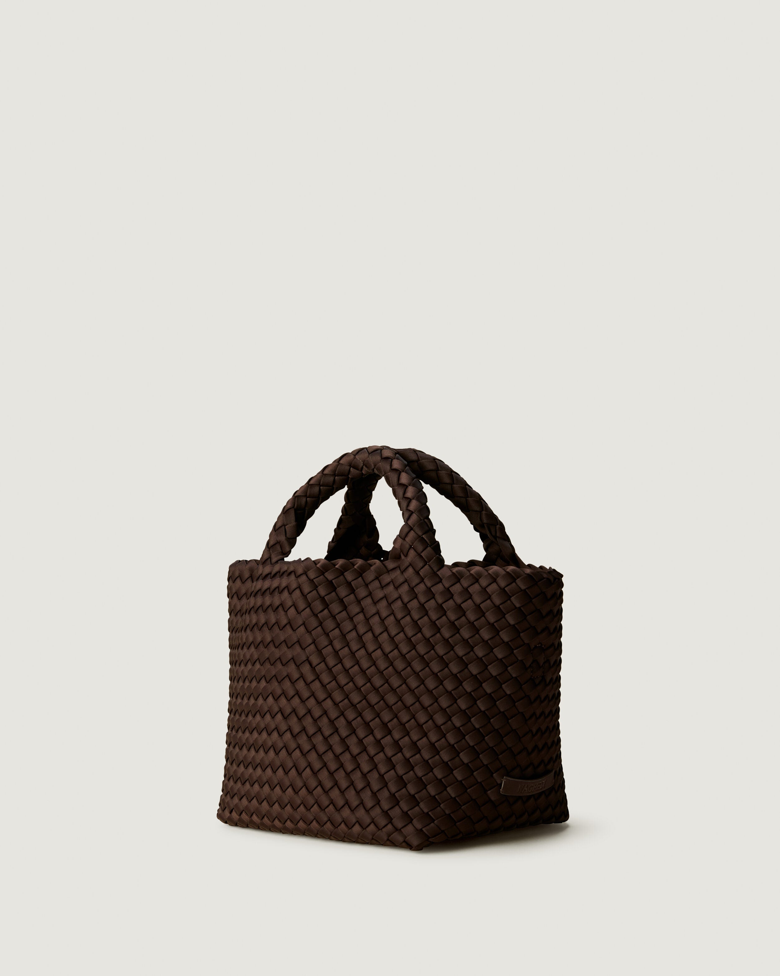 St. Barths Tote in Chocolate shown from a side angle, highlighting its handwoven neoprene construction and open top.
