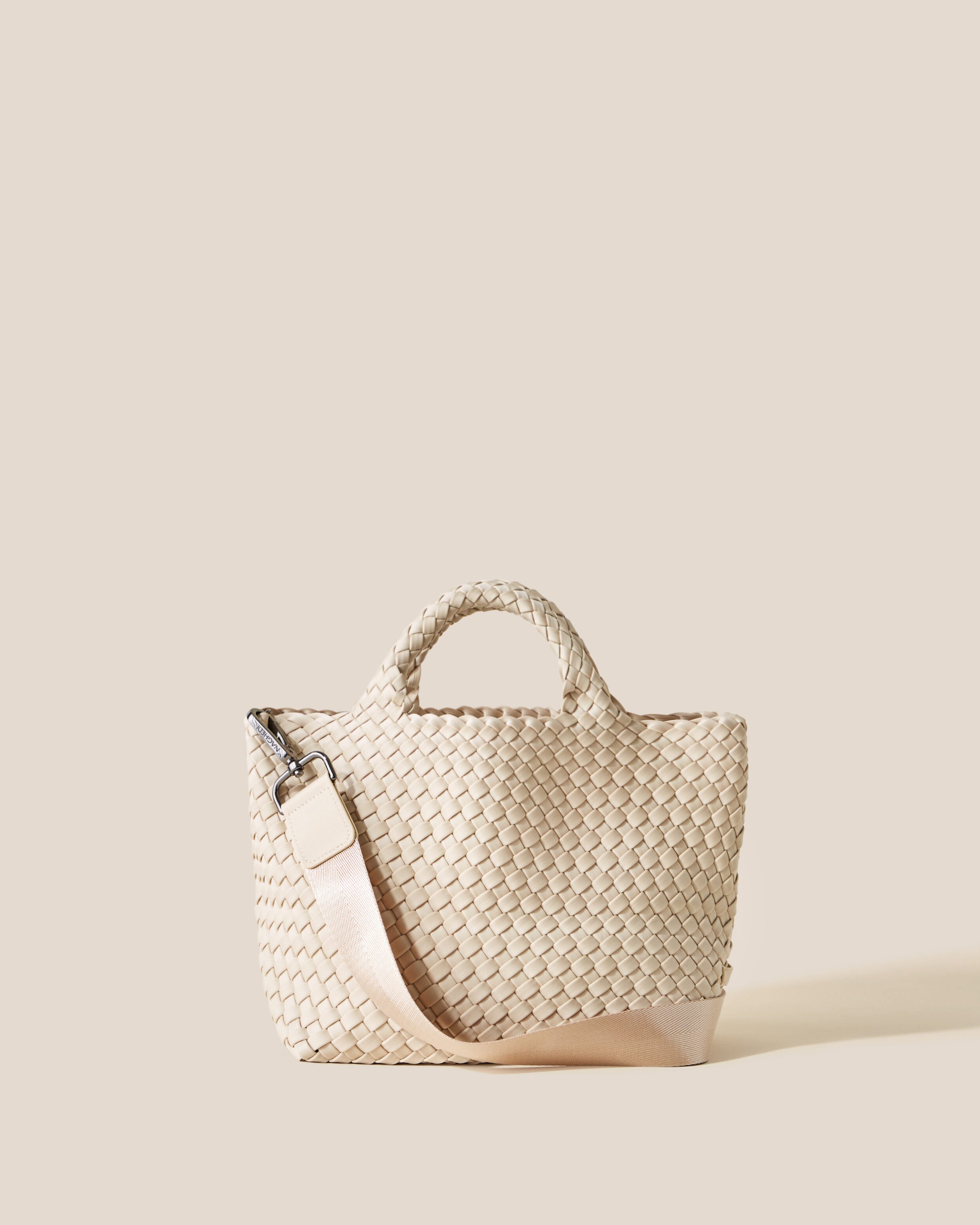 St. Barths Tote in Ecru, a cream tone, in handwoven neoprene, featuring an open top, woven top handles, and detachable, adjustable nylon crossbody strap.