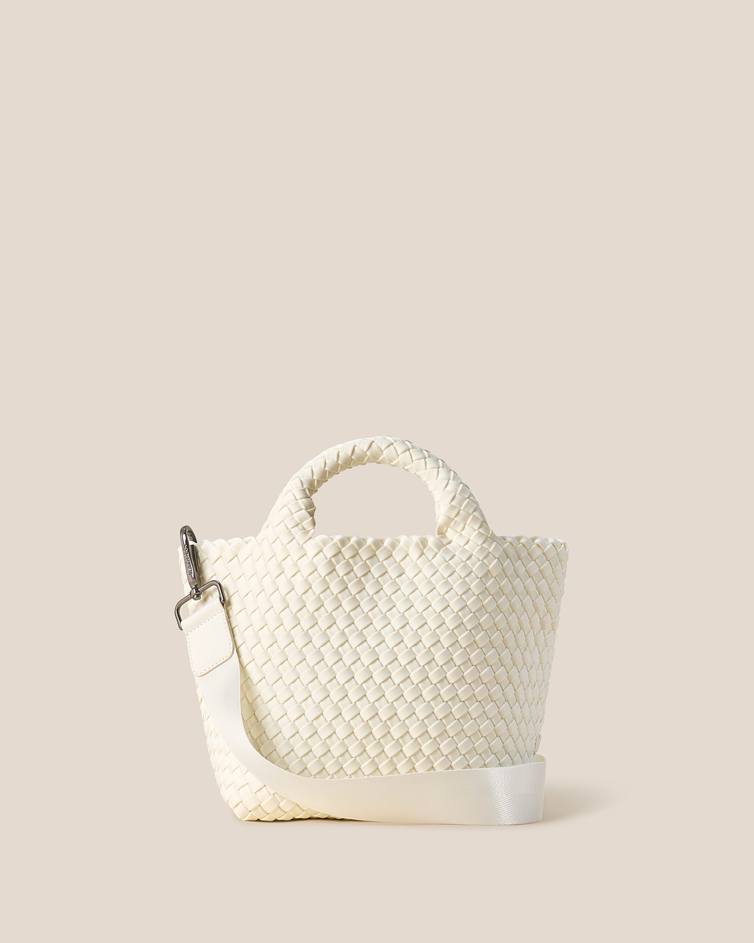St. Barths Tote in Jasmine, an ivory tone, in handwoven neoprene, featuring an open top, woven top handles, and detachable, adjustable nylon crossbody strap.