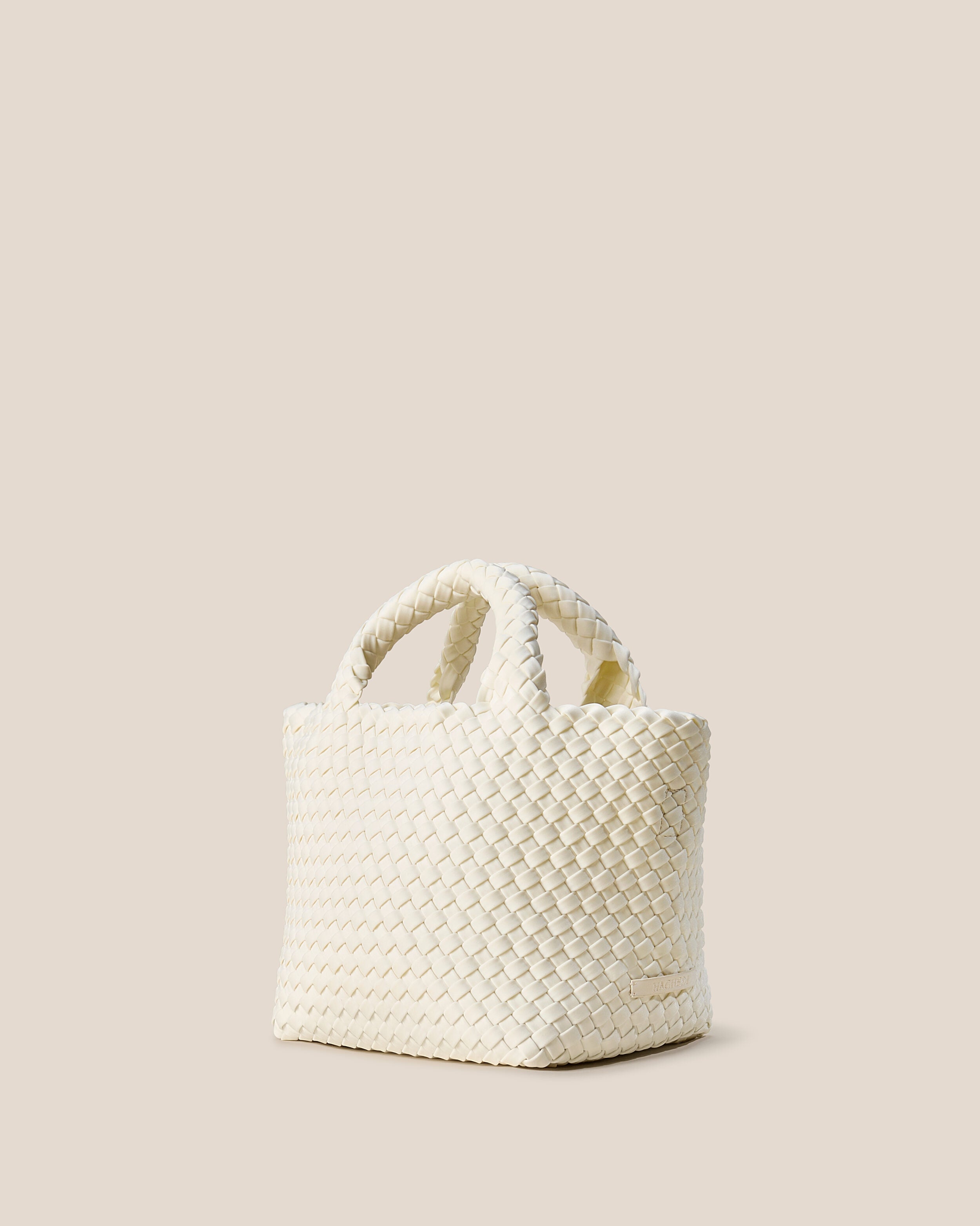 St. Barths Tote in Jasmine shown from a side angle, highlighting its handwoven neoprene construction and open top.