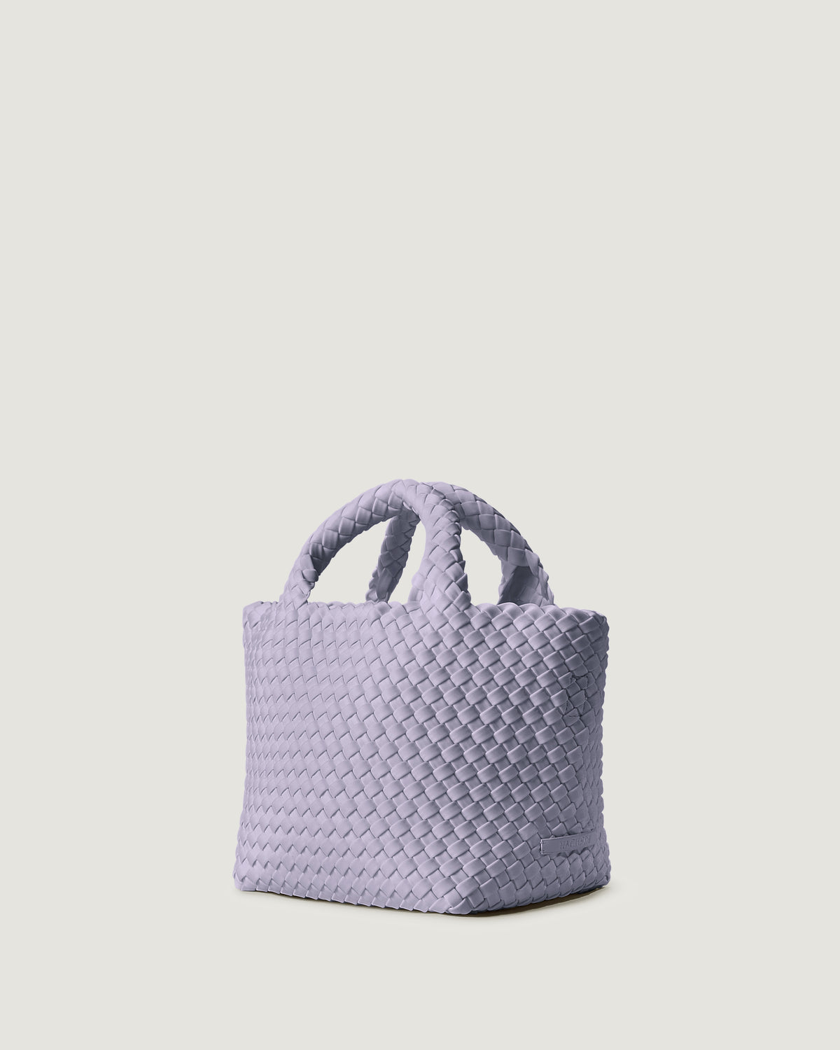 St. Barths Tote in Lilac shown from a side angle, highlighting its handwoven neoprene construction and open top with magnetic snap closure.