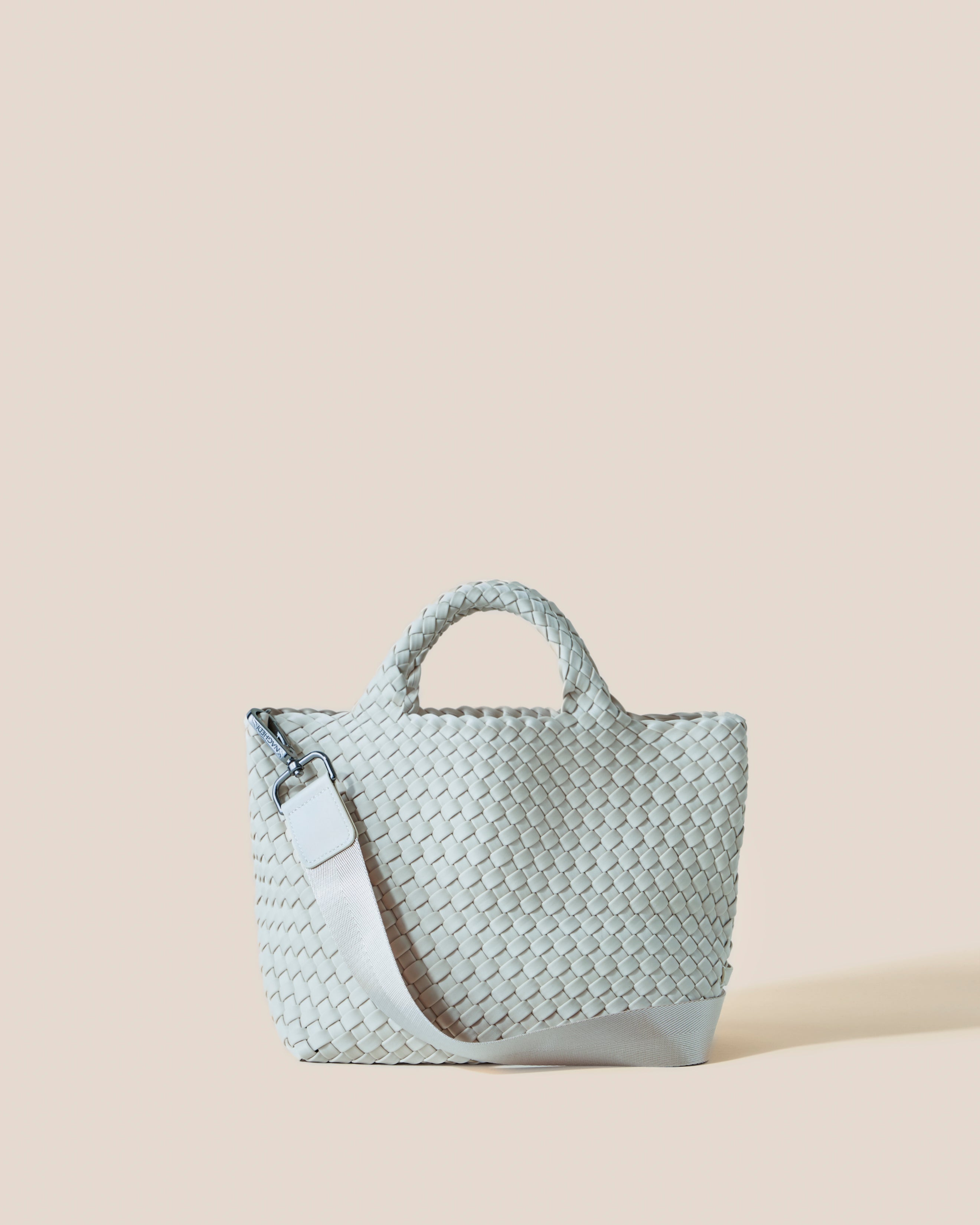 St. Barths Tote in mist, a light blue tone, in handwoven neoprene, featuring an open top, woven top handles, and detachable, adjustable nylon crossbody strap.