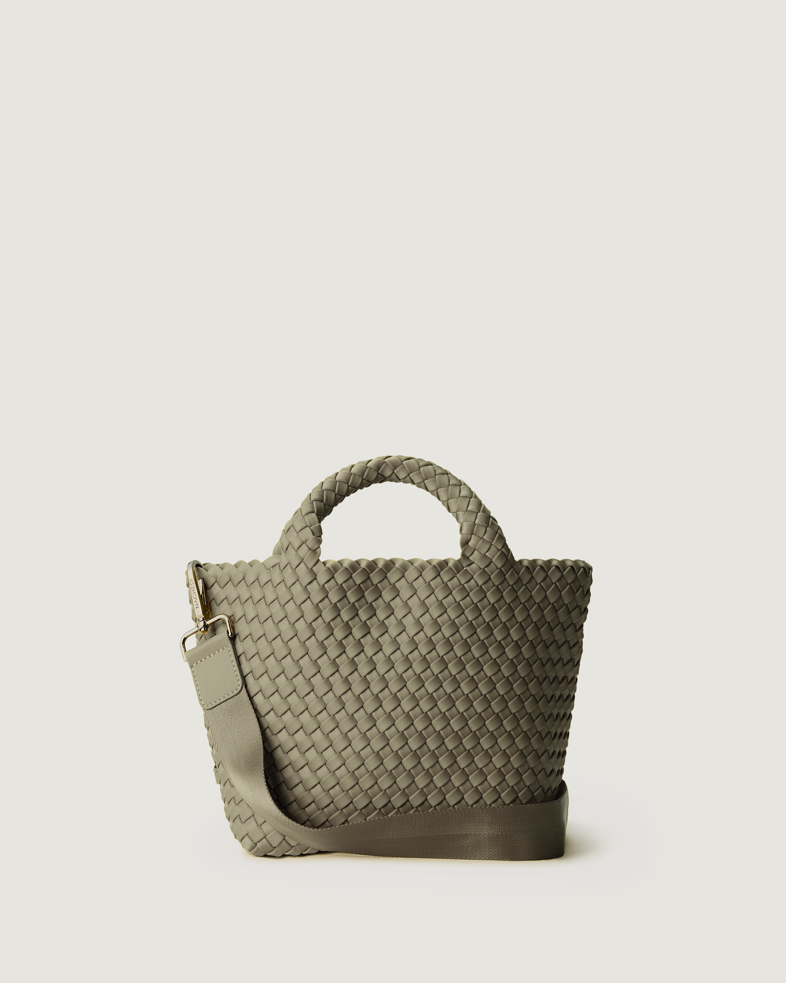 St. Barths Tote in Olea, a sage green tone, in handwoven neoprene, featuring an open top, woven top handles, and detachable, adjustable nylon crossbody strap.