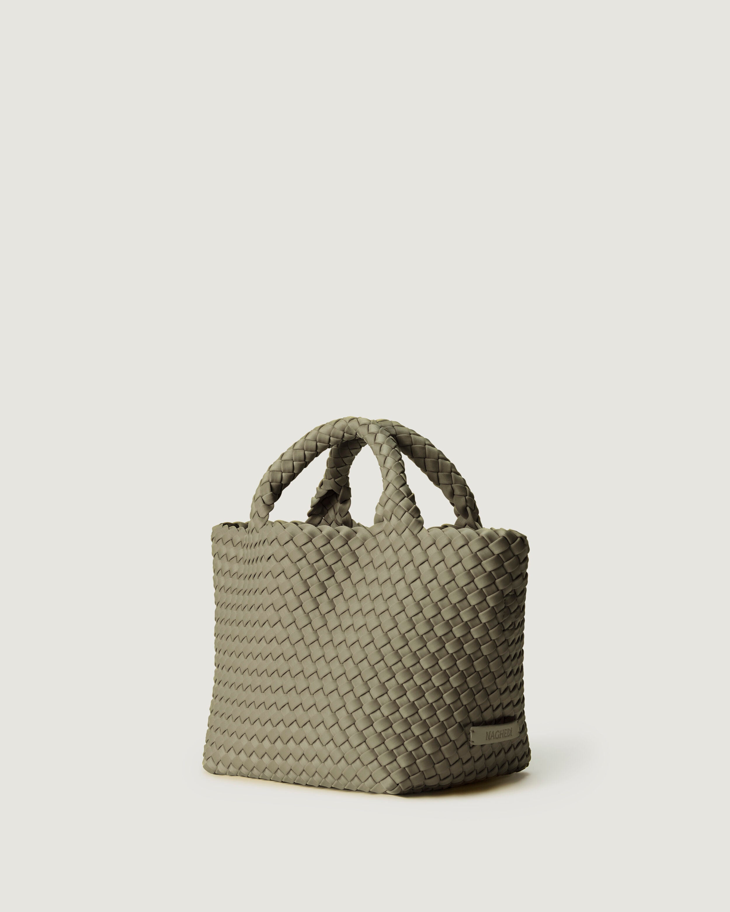 St. Barths Tote in Olea shown from a side angle, highlighting its handwoven neoprene construction and open top.