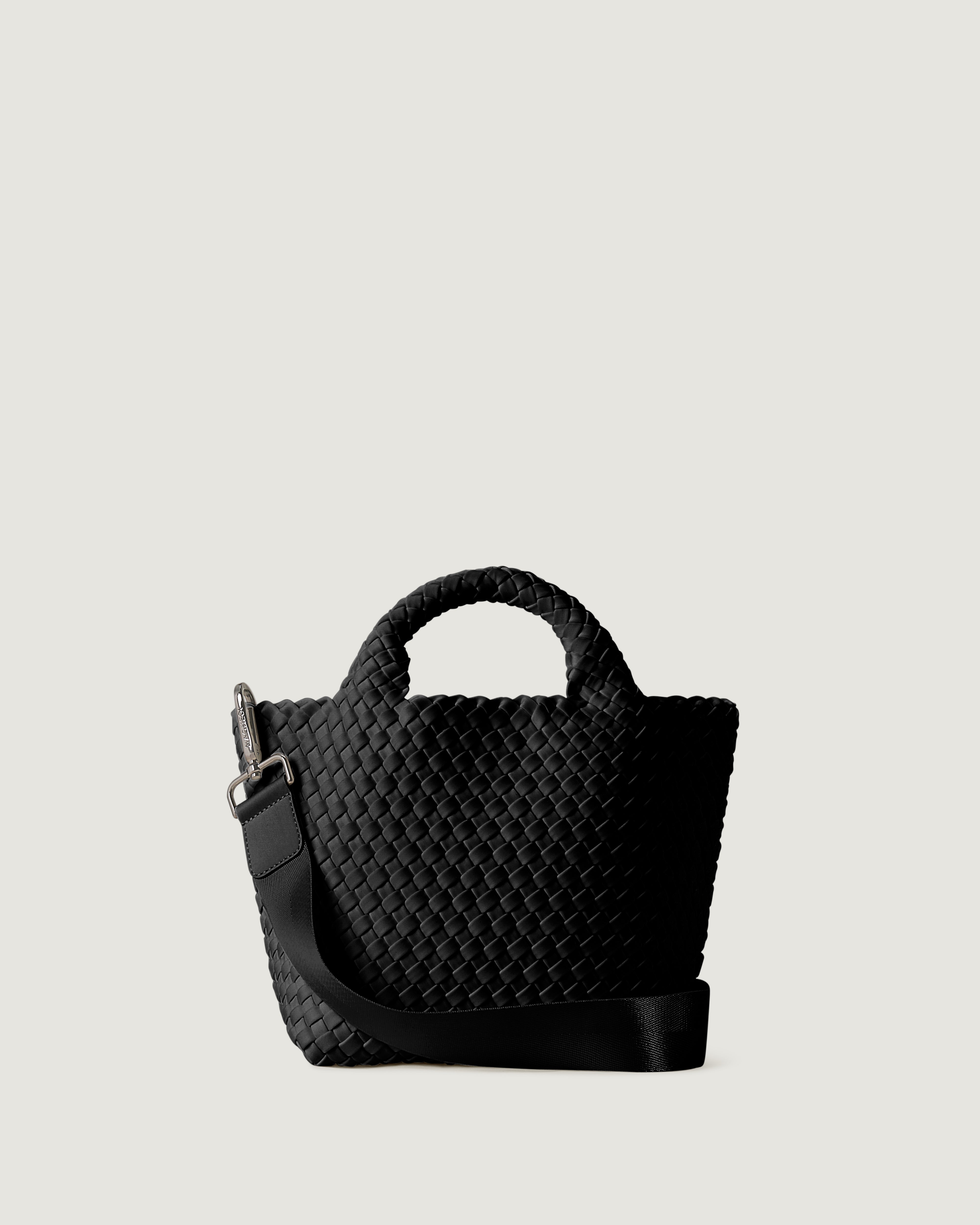 St. Barths Tote in Onyx, a true black tone, in handwoven neoprene, featuring an open top, woven top handles, and detachable, adjustable nylon crossbody strap.