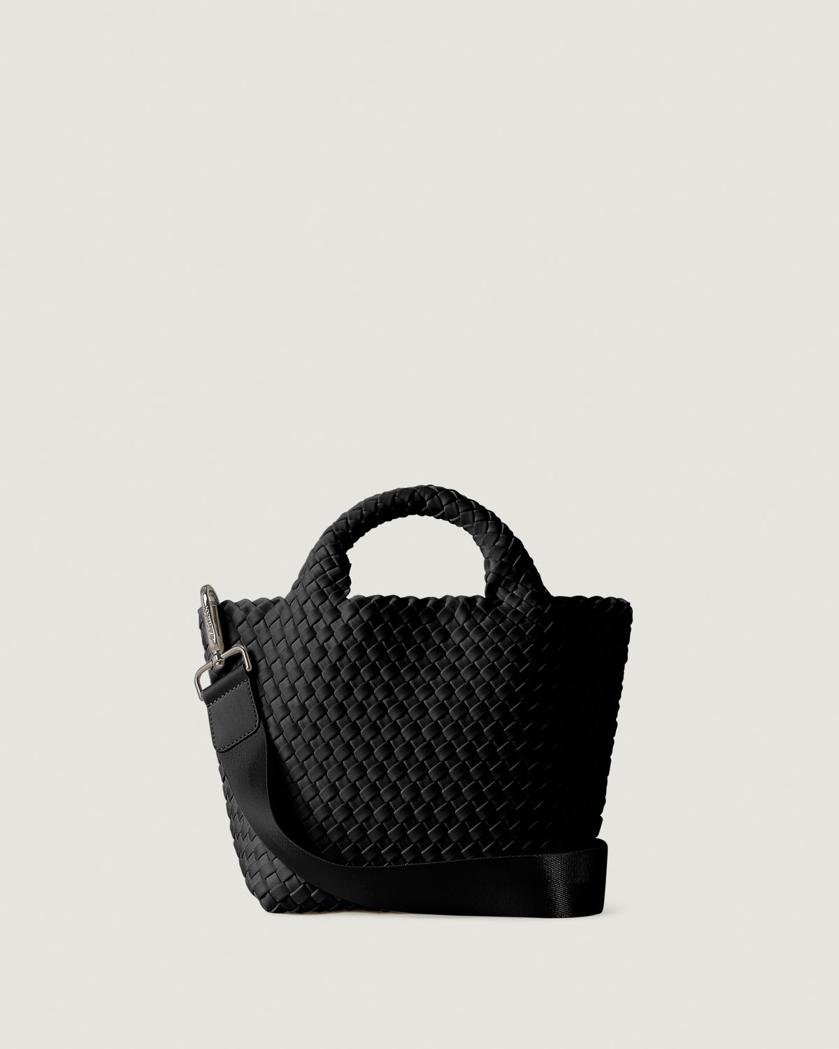 St. Barths Tote in Onyx, a true black tone, in handwoven neoprene, featuring an open top, woven top handles, and detachable, adjustable nylon crossbody strap.