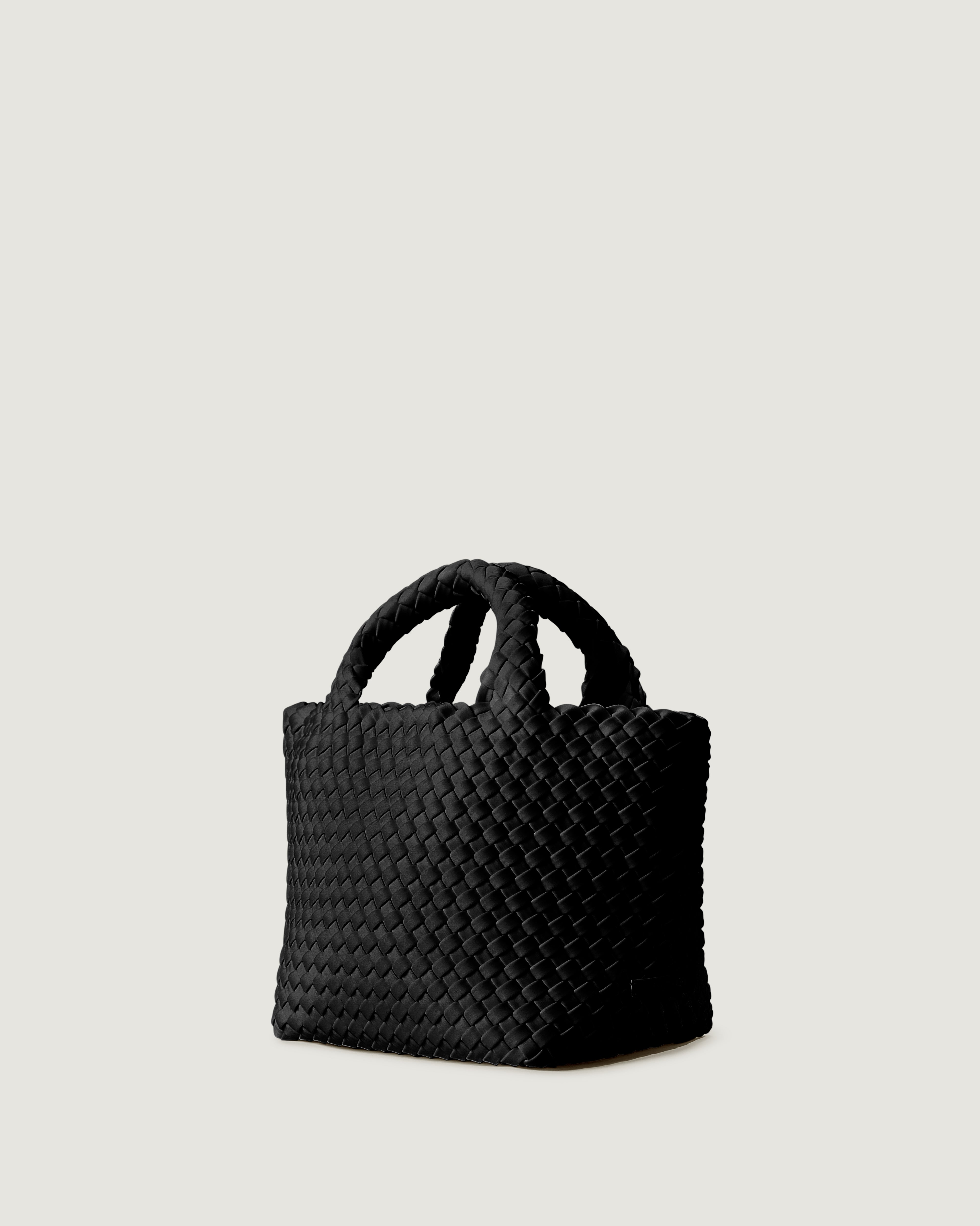 St. Barths Tote in Onyx shown from a side angle, highlighting its handwoven neoprene construction and open top.