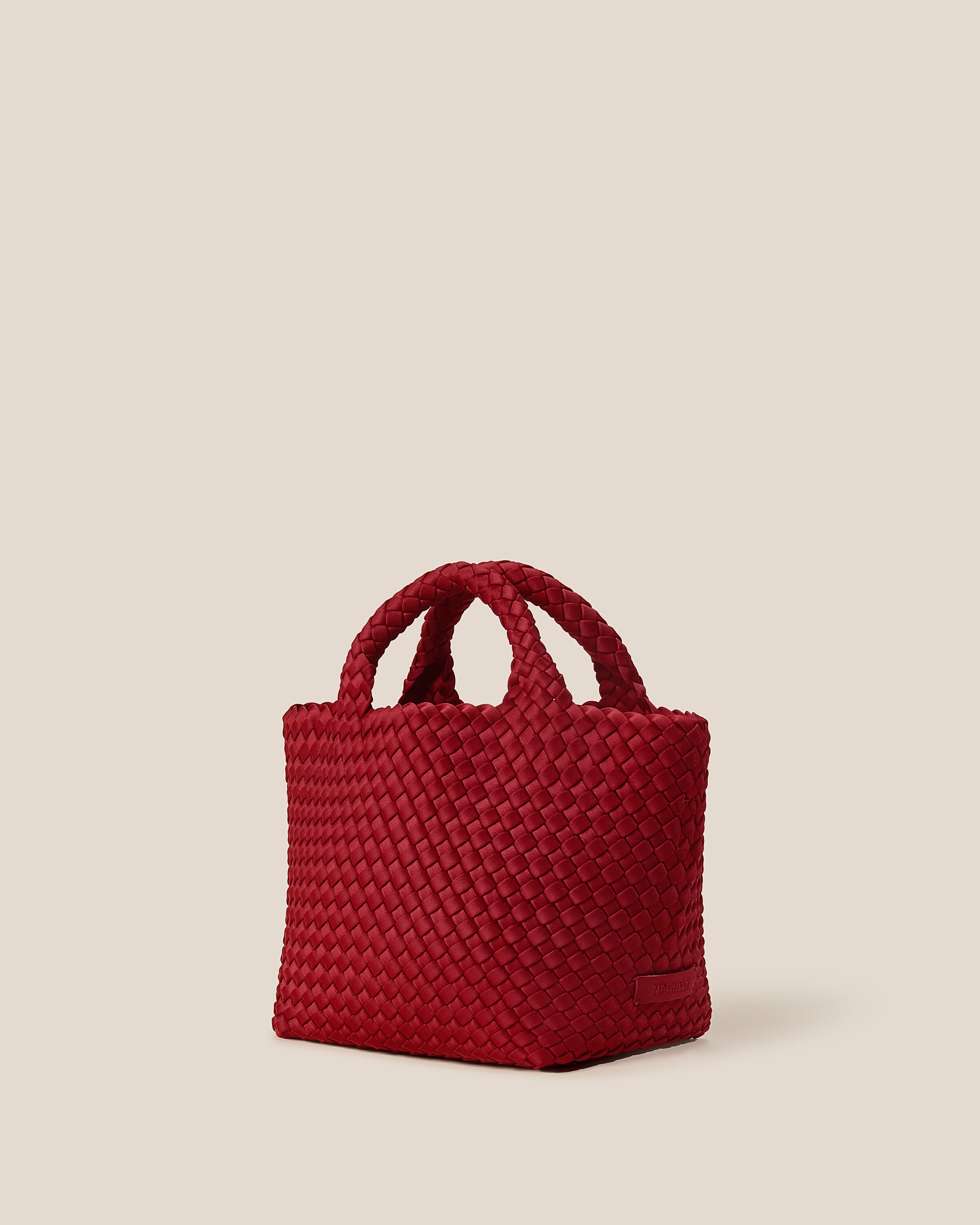 St. Barths Tote in Rosso shown from a side angle, highlighting its handwoven neoprene construction and open top.