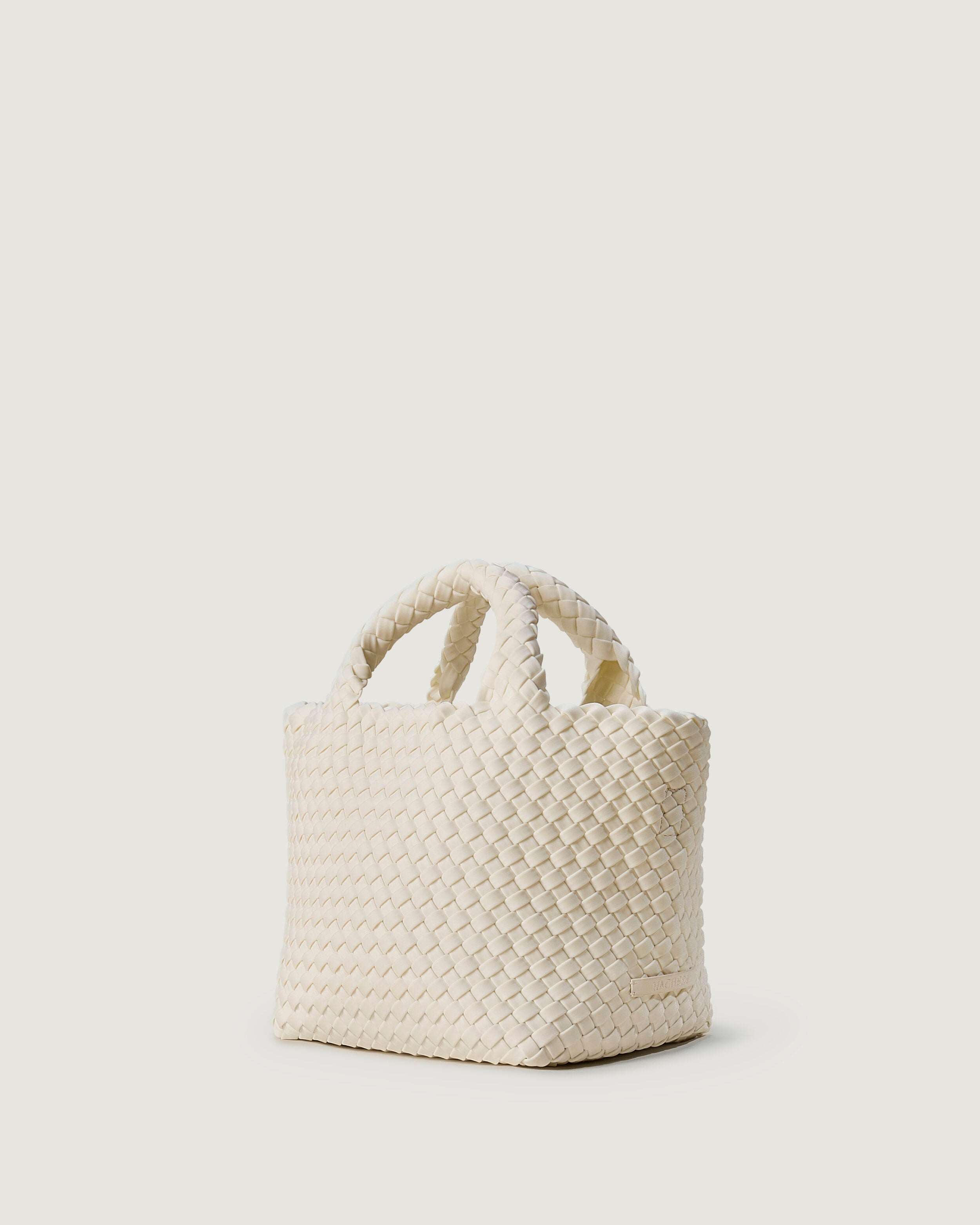 St. Barths Tote in Salt shown from a side angle, highlighting its handwoven neoprene construction and open top.
