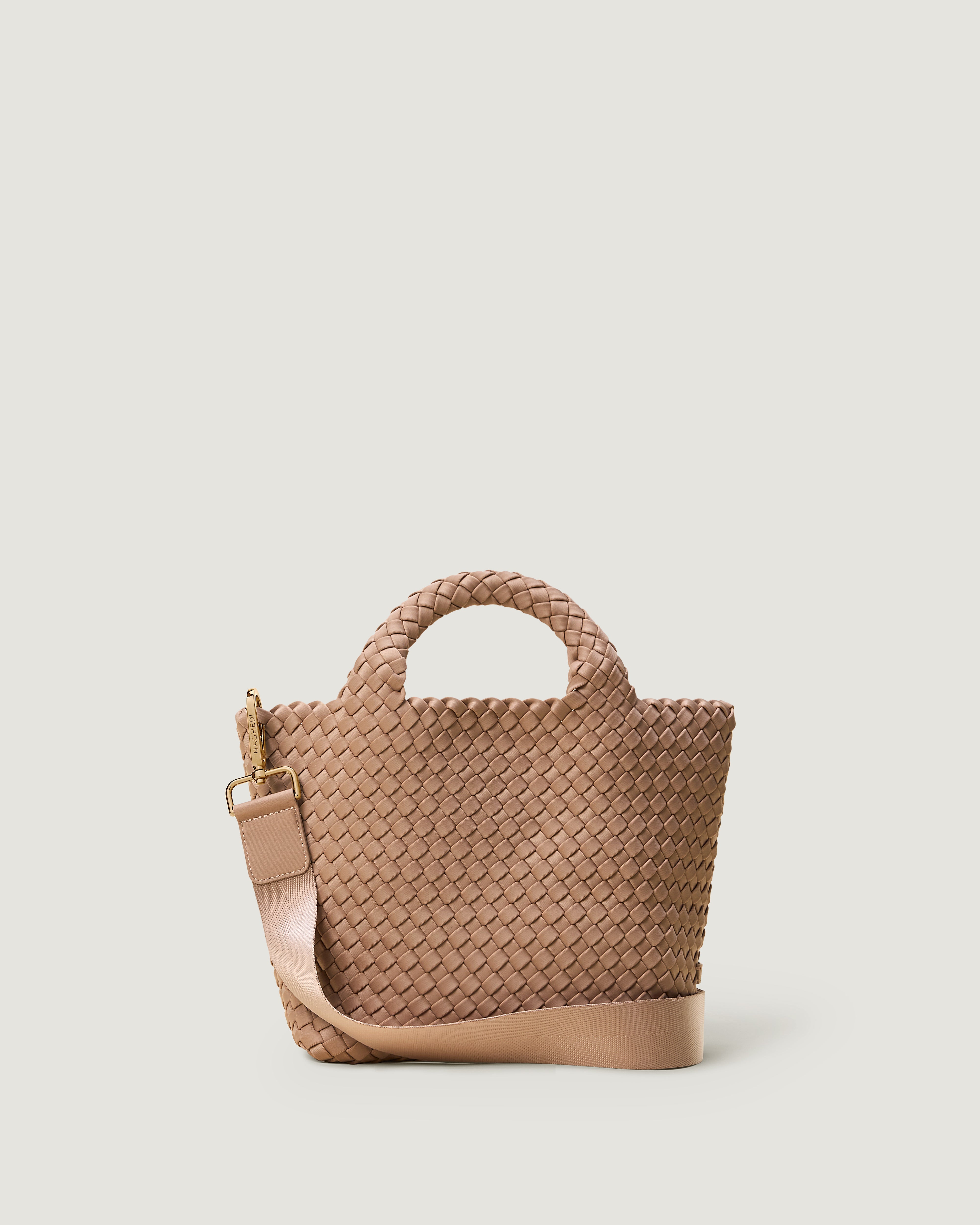 St. Barths Tote in Turmeric, handwoven in mocha neoprene. Featuring an open top, adjustable shoulder strap, and woven top handles.