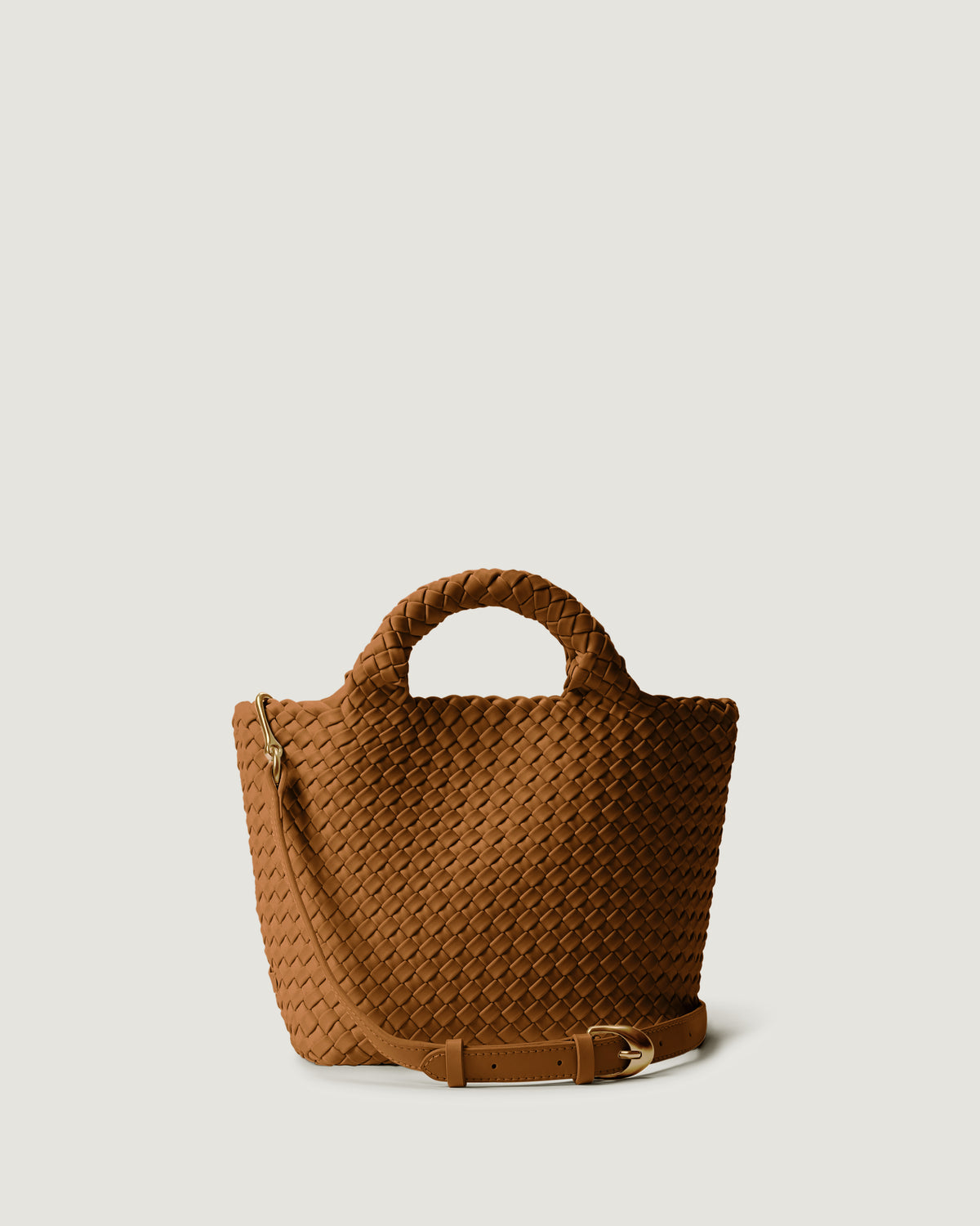 St. Barths Tote in Teak, a saddle brown tone, in handwoven neoprene, featuring a magnetic closure, woven top handles, and detachable, adjustable leather crossbody strap.
