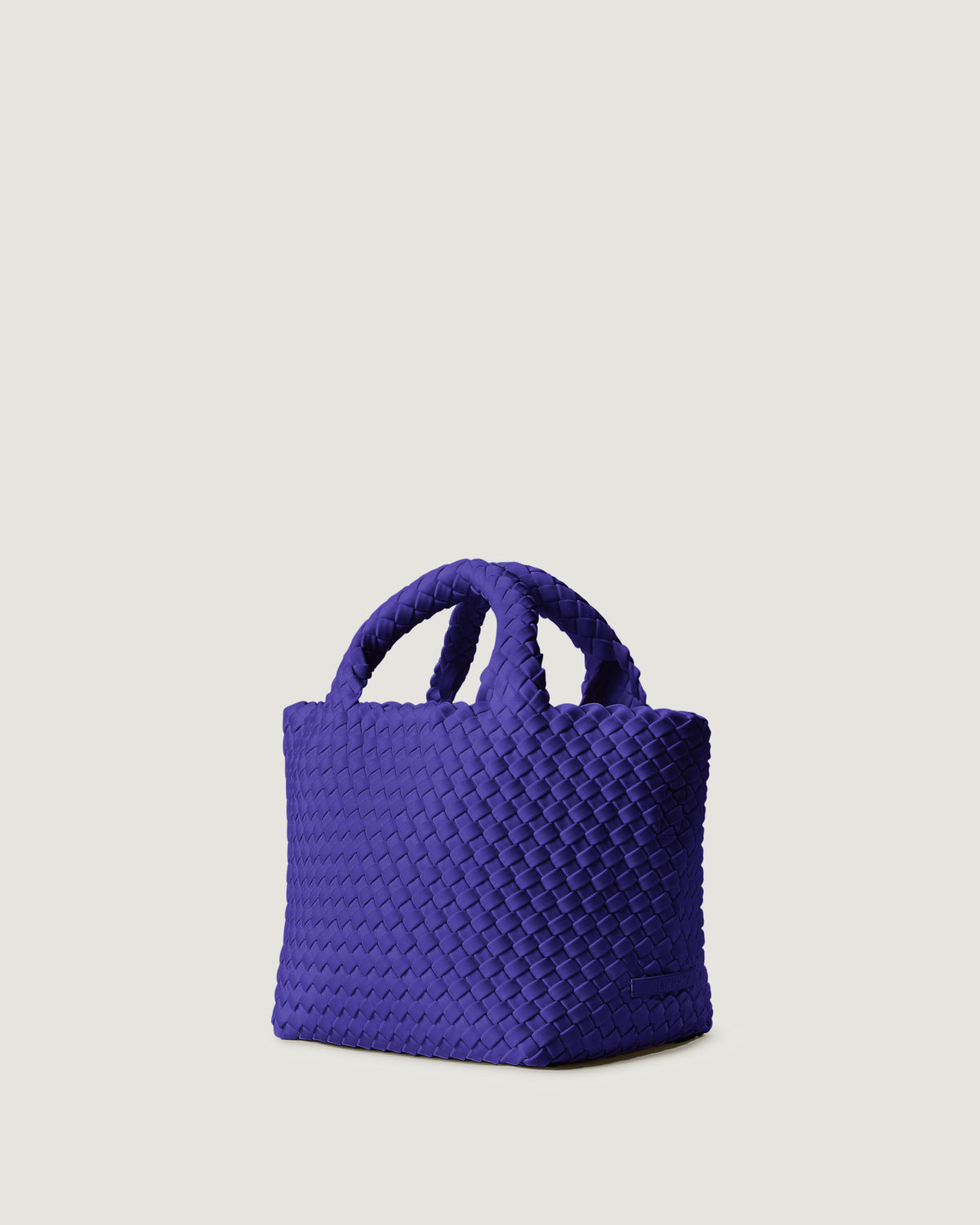 St. Barths Tote in Ultramarine shown from a side angle, highlighting its handwoven neoprene construction and open top with magnetic snap closure.