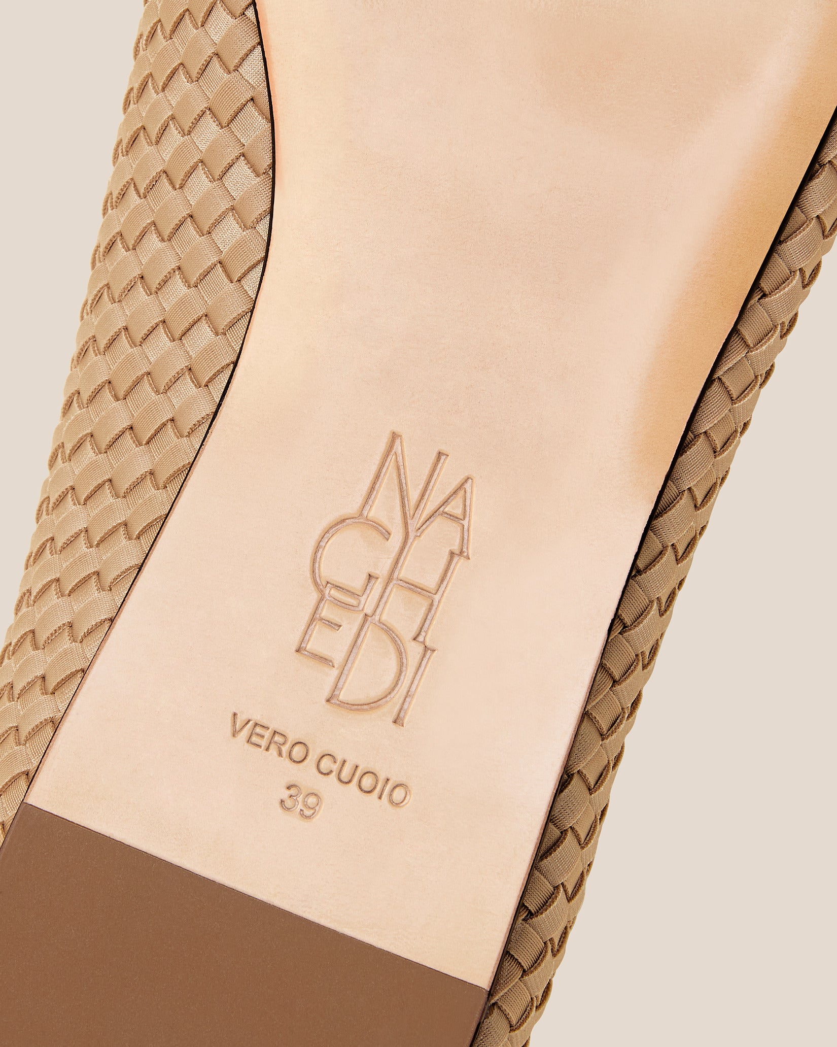 Shoe sole showing natural buffed leather sole, stamped NAGHEDI logo and size detail for Strada Flats in Camel.