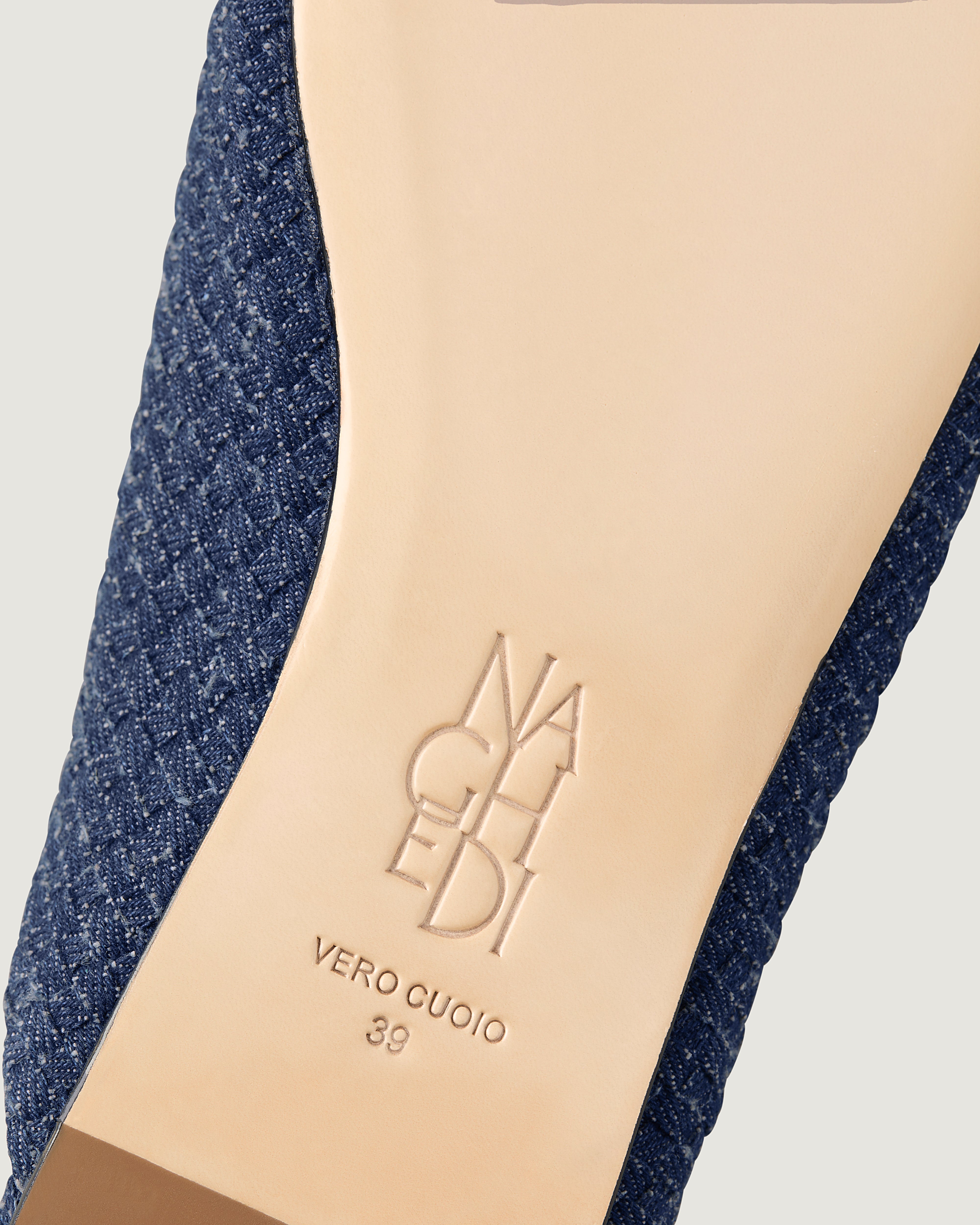 Shoe sole showing natural buffed leather sole, stamped NAGHEDI logo and size detail for Strada Mule in Denim.