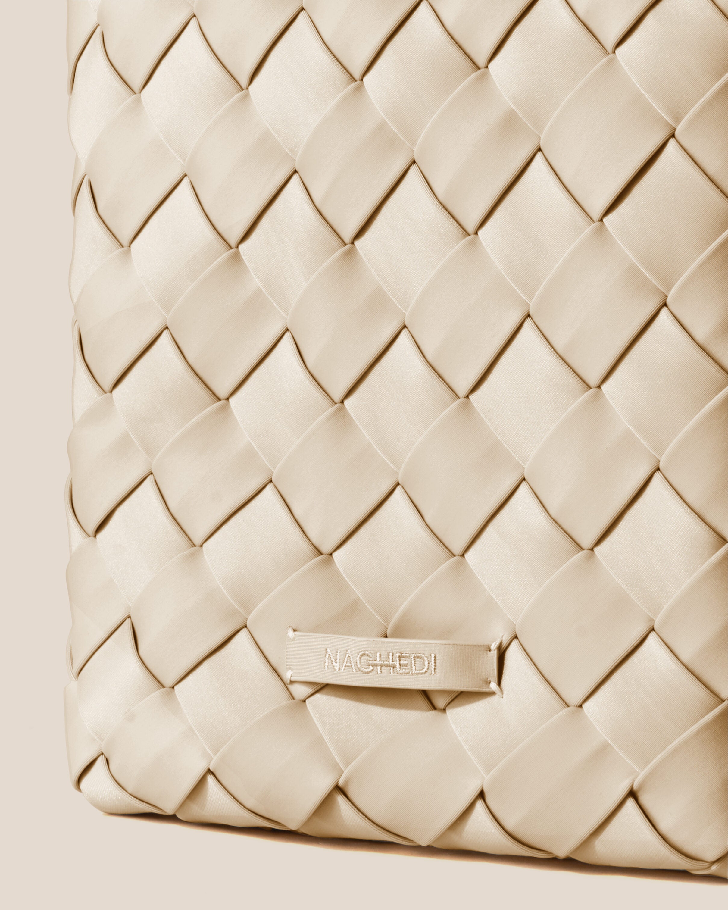 Close-up of stamped NAGHEDI logo on Tangier Tote in Ecru.