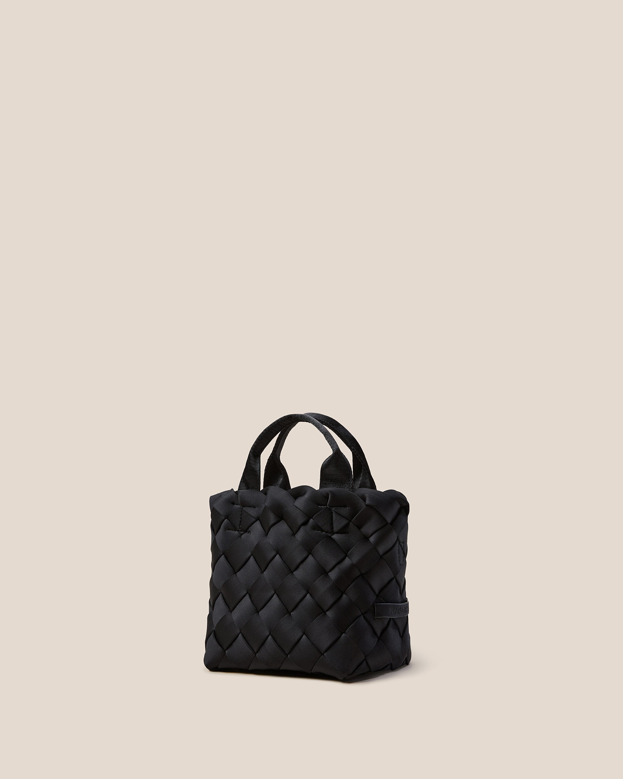 Tangier Tote in Onyx shown from a side angle, highlighting its handwoven neoprene construction and open top.