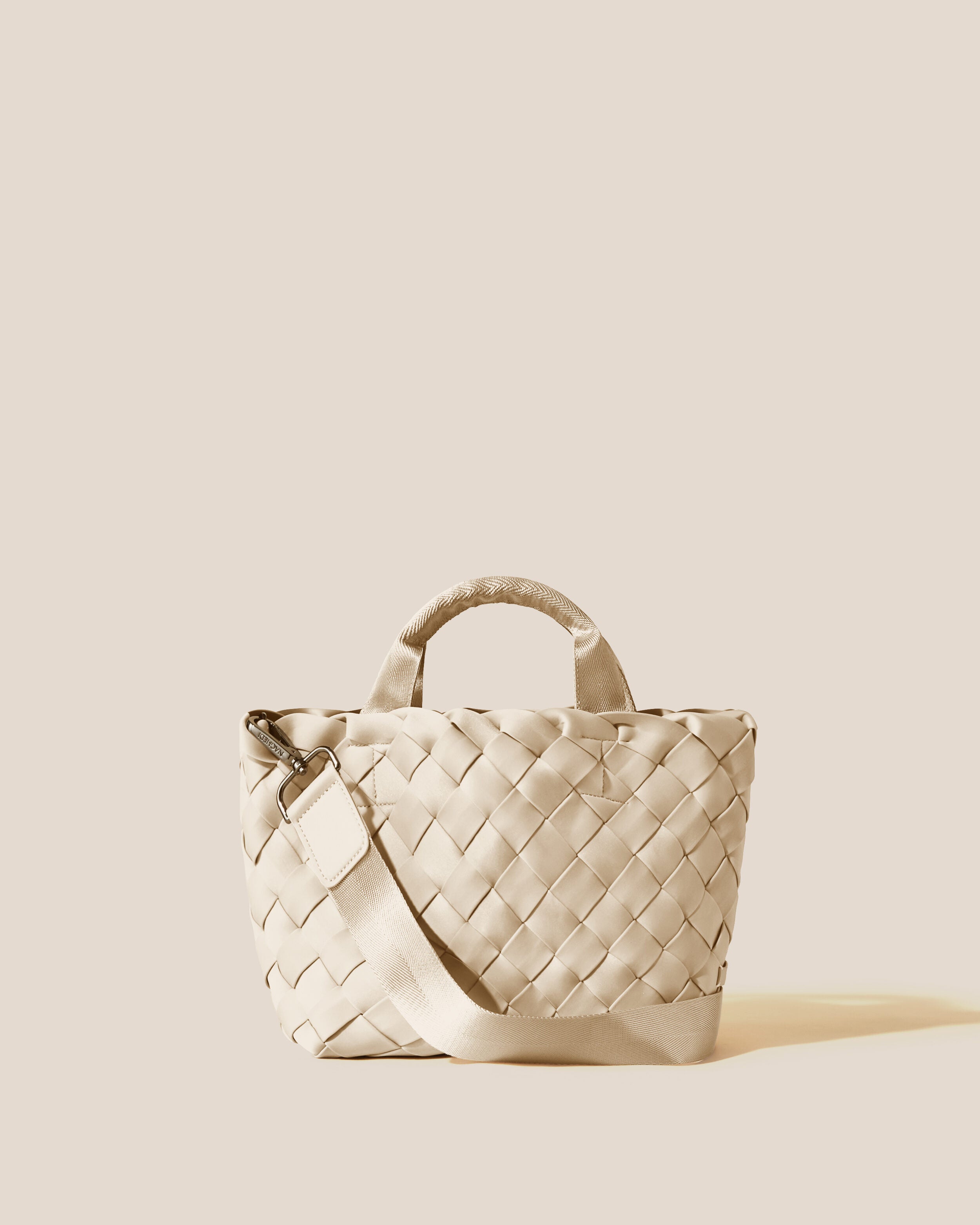 Tangier Tote in Ecru, a cream tone, in handwoven neoprene, featuring an open top, sleek nylon webbing handles, and detachable, adjustable nylon crossbody strap.