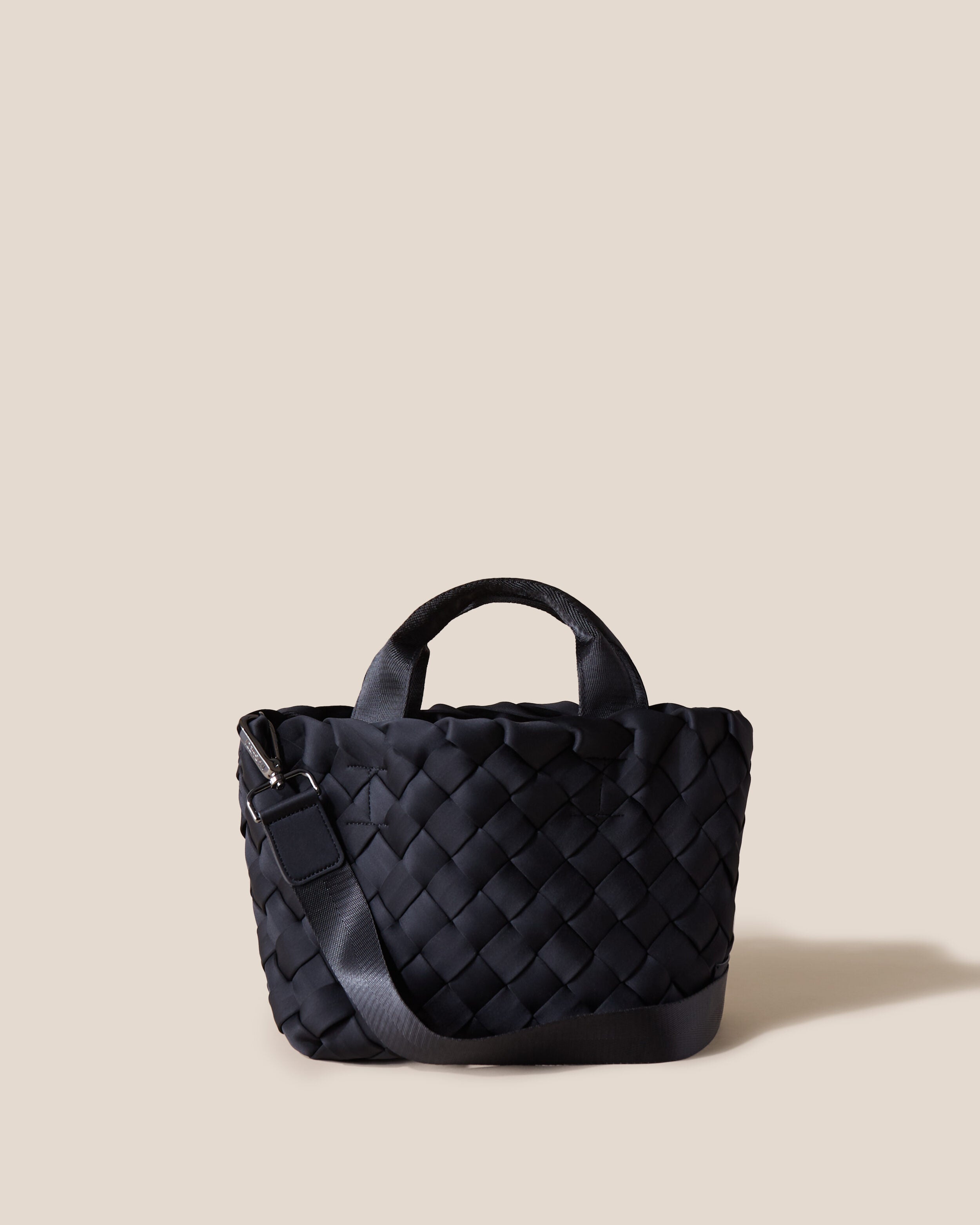 Tangier Tote in Onyx, a true black tone, in handwoven neoprene, featuring an open top, sleek nylon webbing handles, and detachable, adjustable nylon crossbody strap.